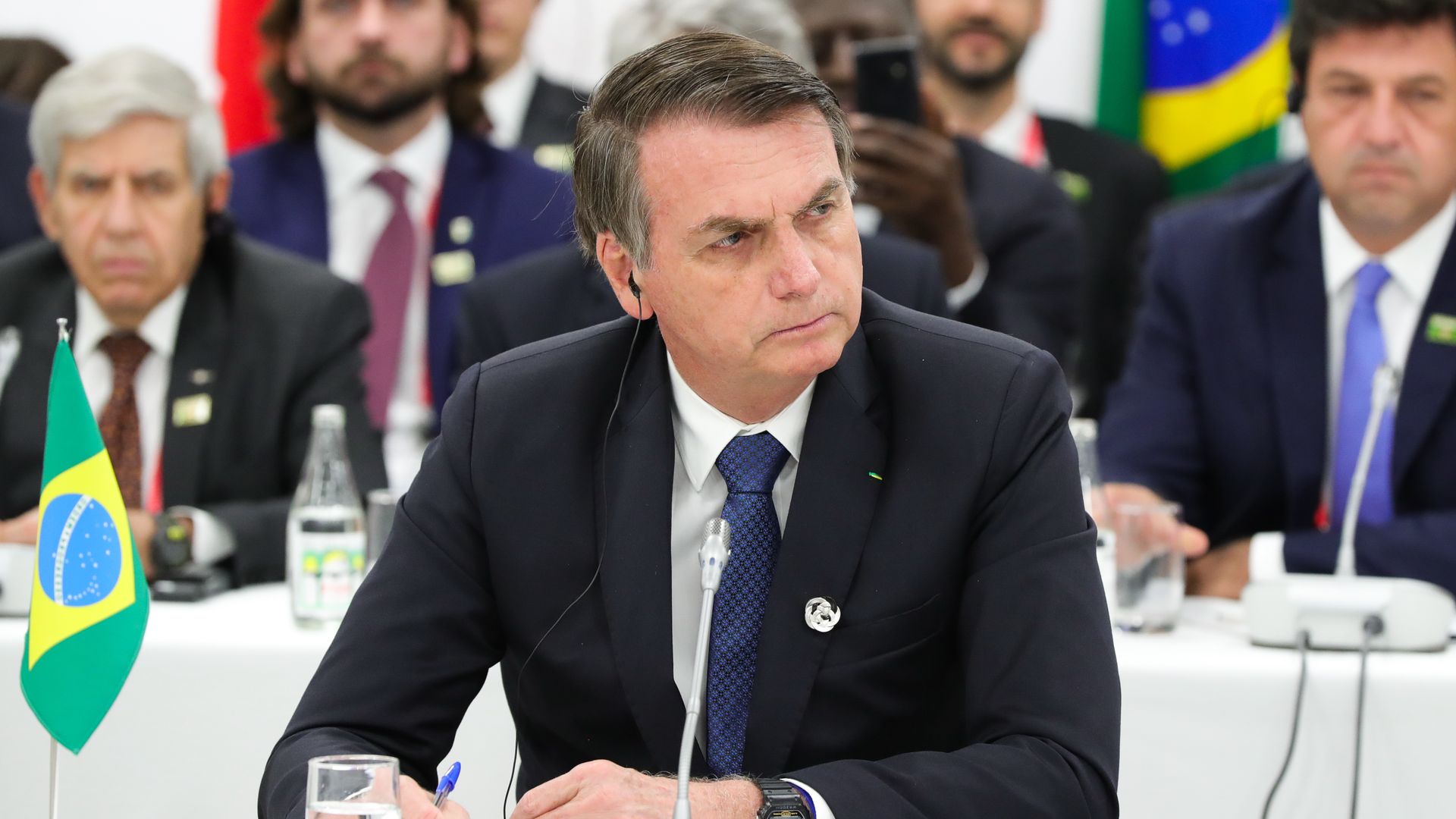 Bolsonaro sitting down and looking to the side. 
