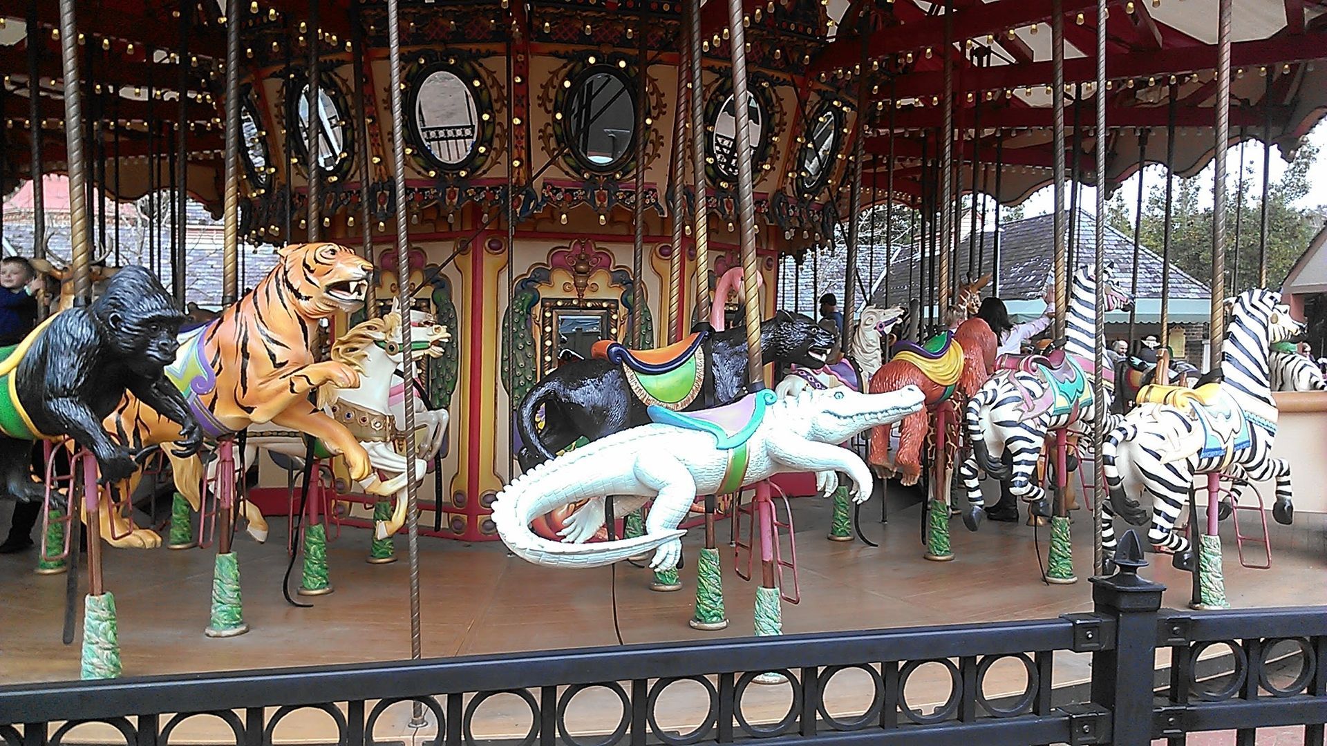 Photo shows a carouse with a white gator and other animals.