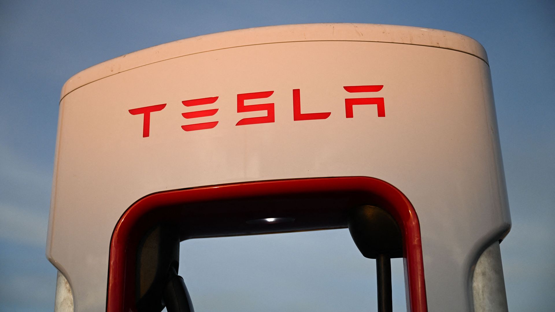 The Tesla, Inc. electric vehicle logo is displayed on a charging bay 