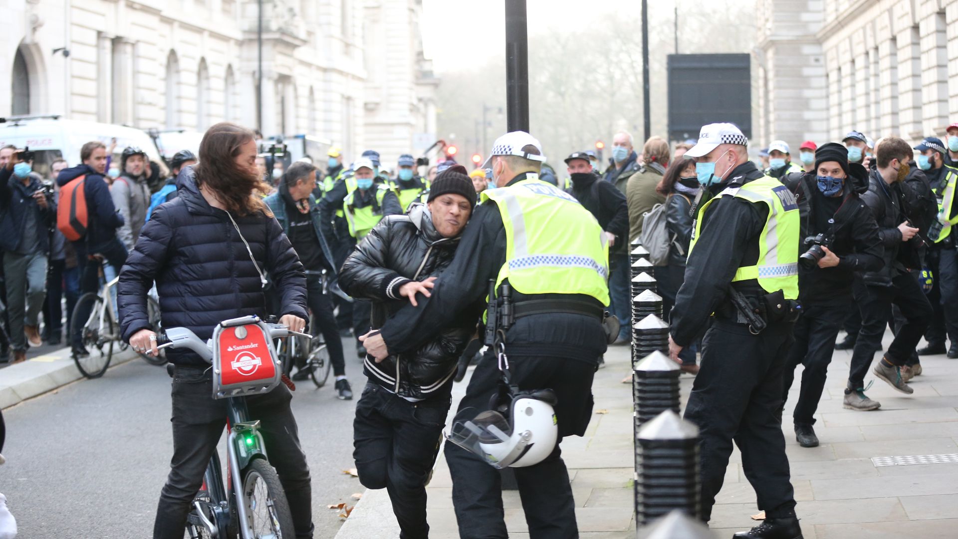 Police officers intervene a protestor as anti-lockdown and anti-vaccine protesters stage a march in central London, England