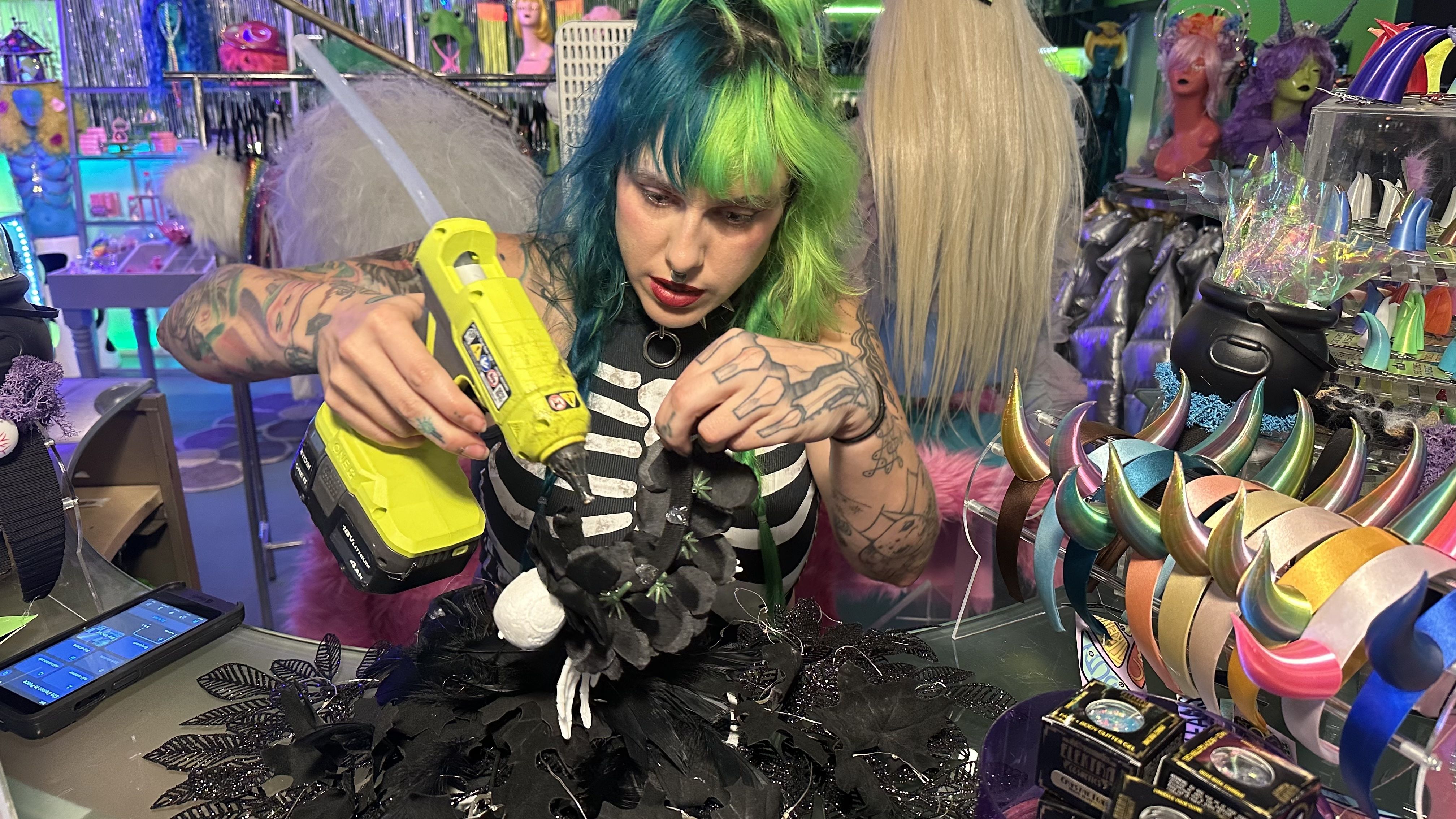 Photo shows a woman with a hot glue gun.