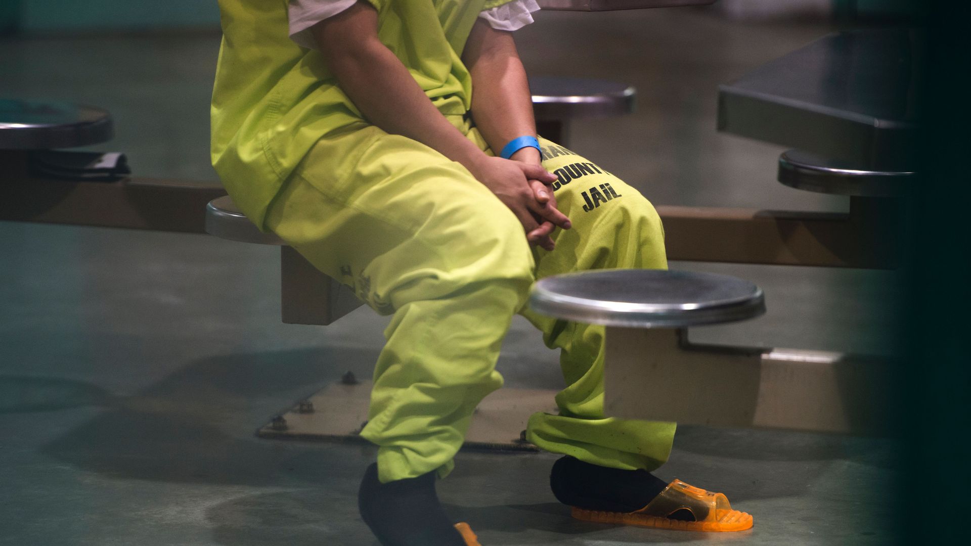 A detainee in California sits with his hands in his lap.
