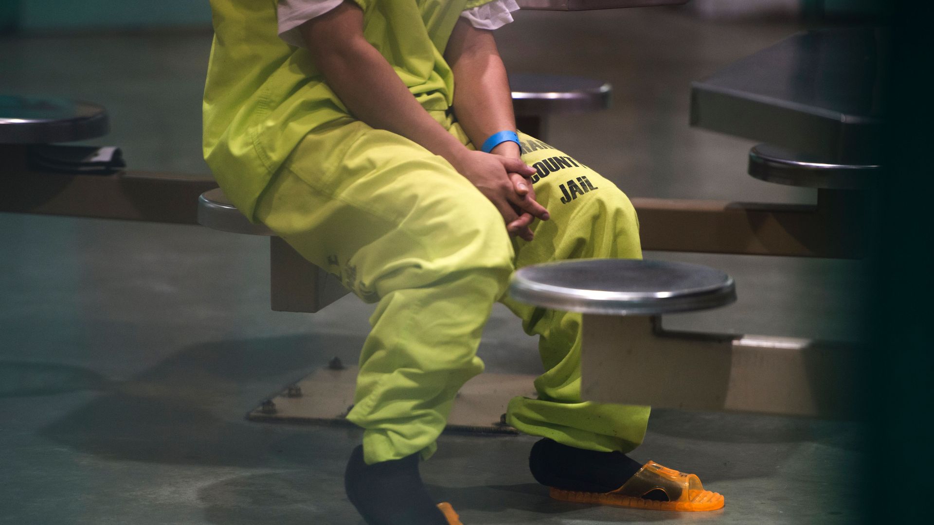 A detainee in California sits with his hands in his lap.