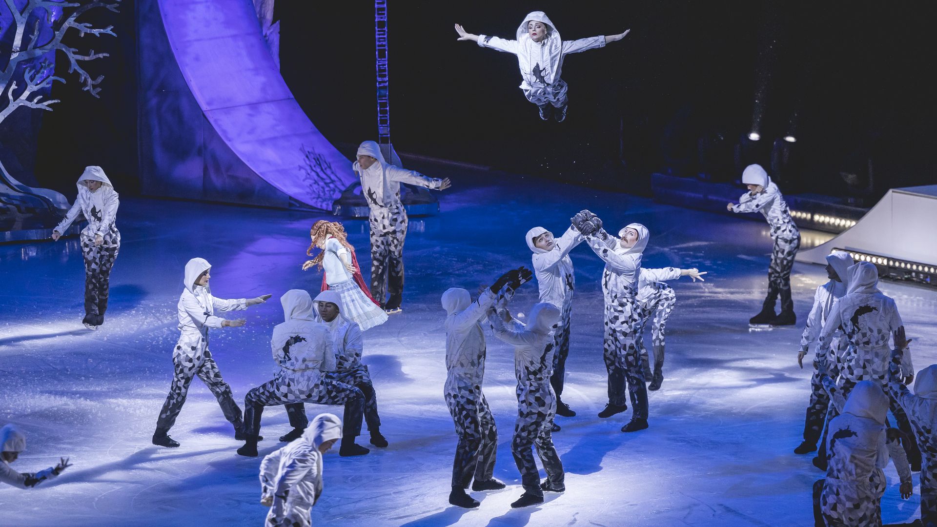 Cirque du Soleil performers jump and skate on ice. 