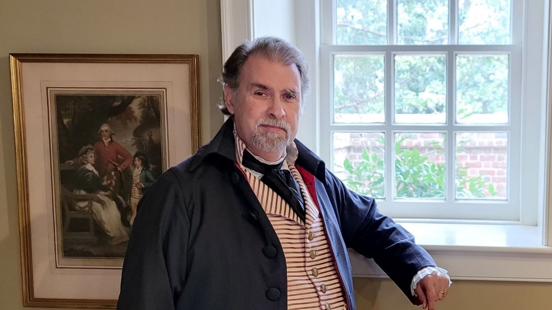 Tom Plott, head of character interpretation at Mount Vernon, dressed in 18th century clothing (a blue wool suite and striped vest) as Dr. James Craik