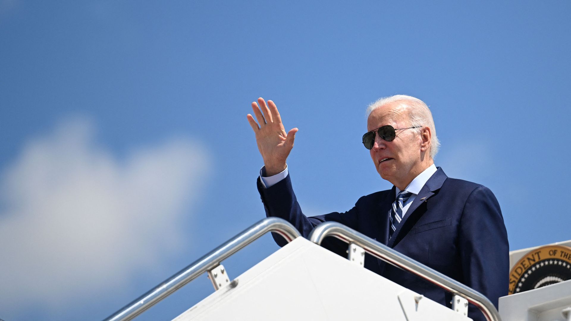 President Joe Biden waves while boarding Air Force One at Joint Base Andrews in Maryland on August 30, 2022