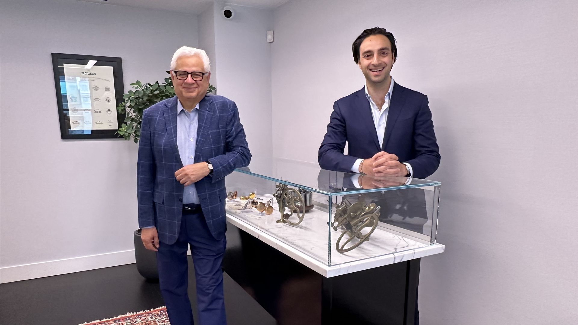 Albert Ganjei, left, and his son Joshua, right, pose for a photo in their office in Boston's Back Bay neighborhood.