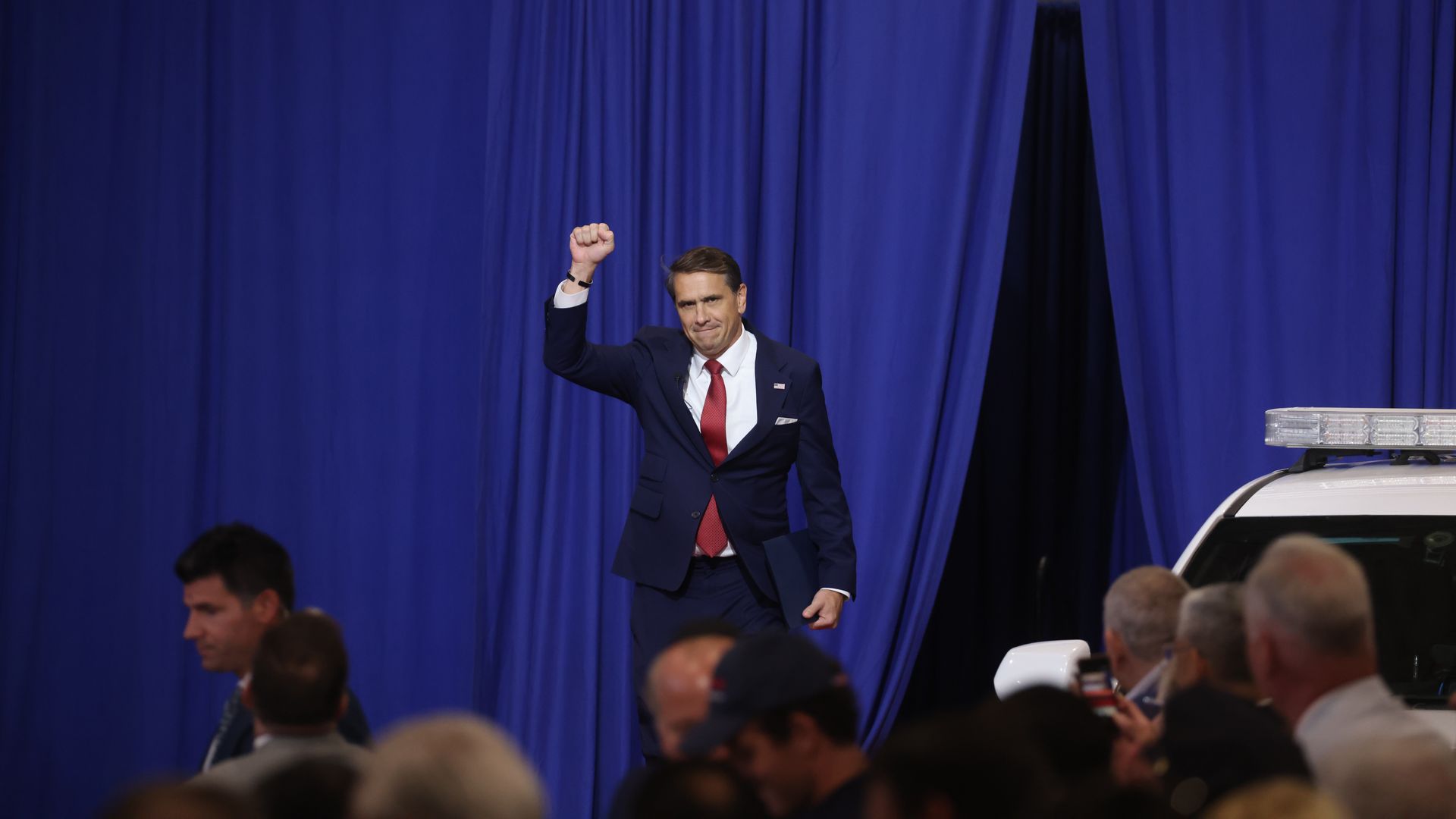 Attorney General Todd Blanche raises a fist while addressing a crowd at the Nassau County Police Academy.