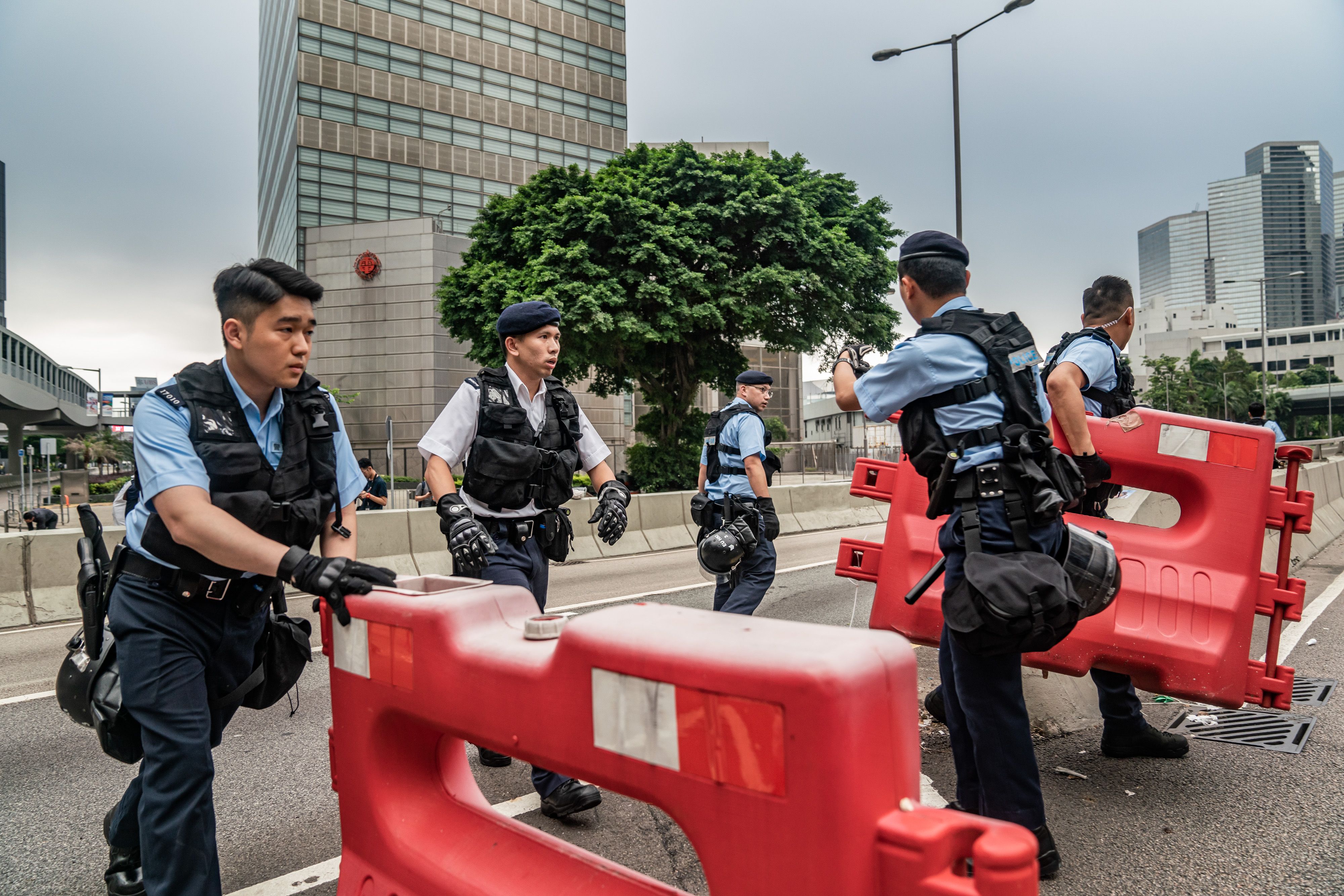  Police officers clear barricades as they attempt to clear the road after a demonstration against the now-suspended extradition bill on June 17, 2019 in Hong Kong.
