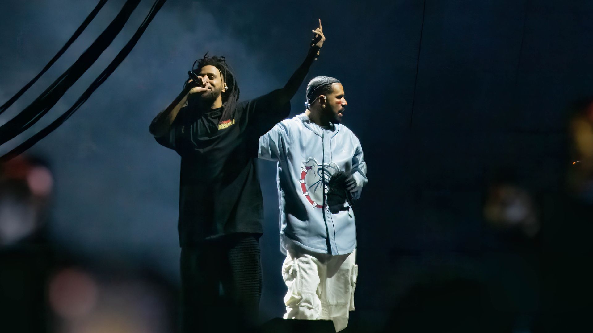 Rappers J. Cole and Drake perform on stage. 