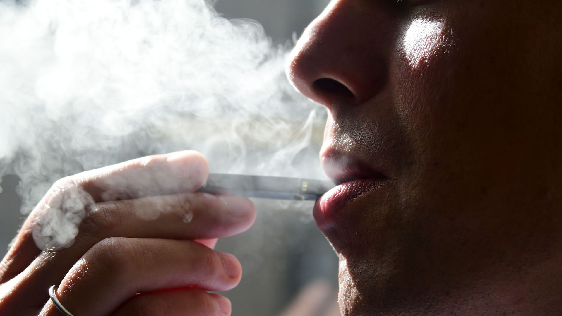 A close-up of a person using an e-cigarette