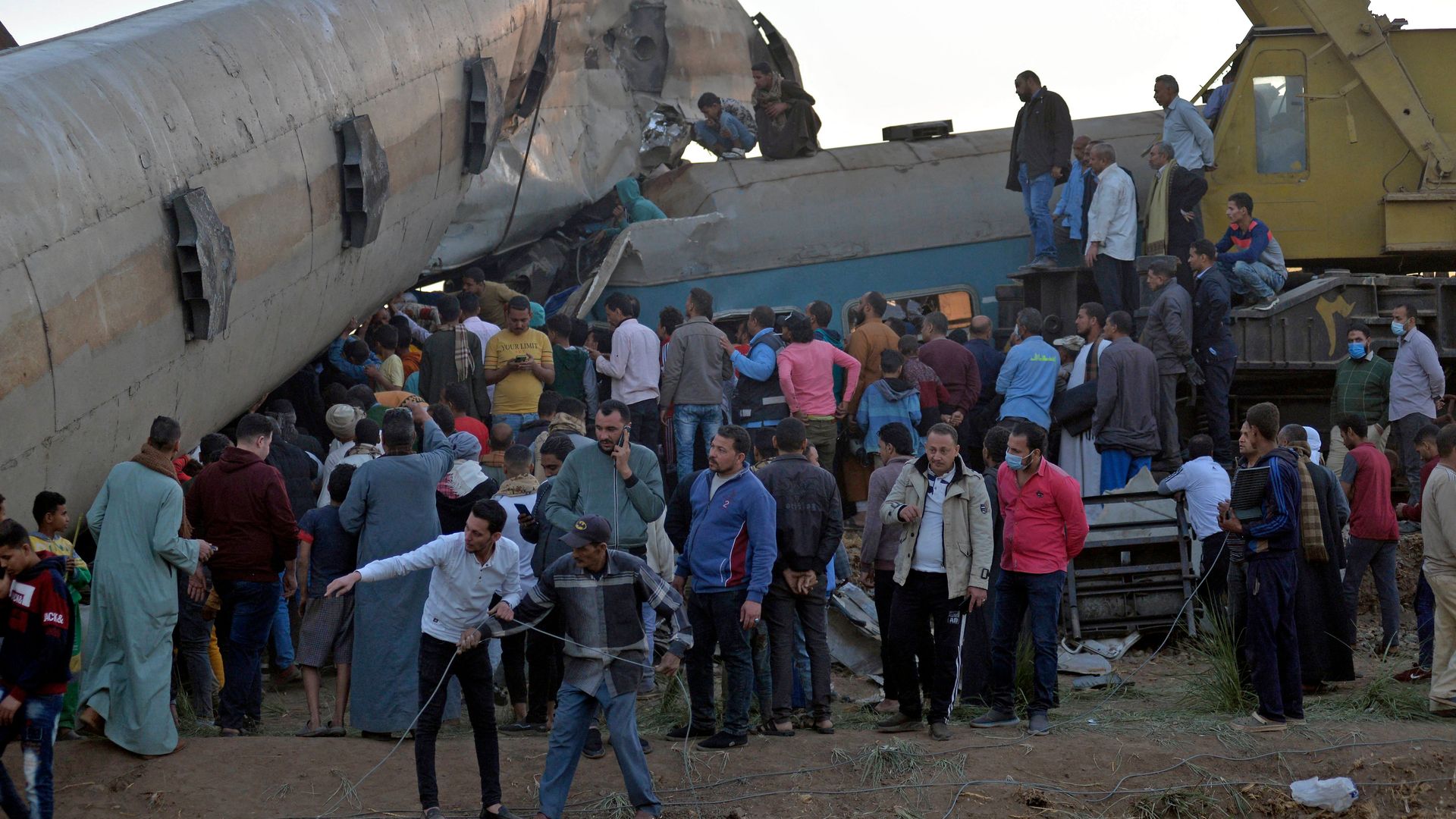 People gathered around the wreckage of two trains that collided in the Tahta district of Sohag province on March 26.