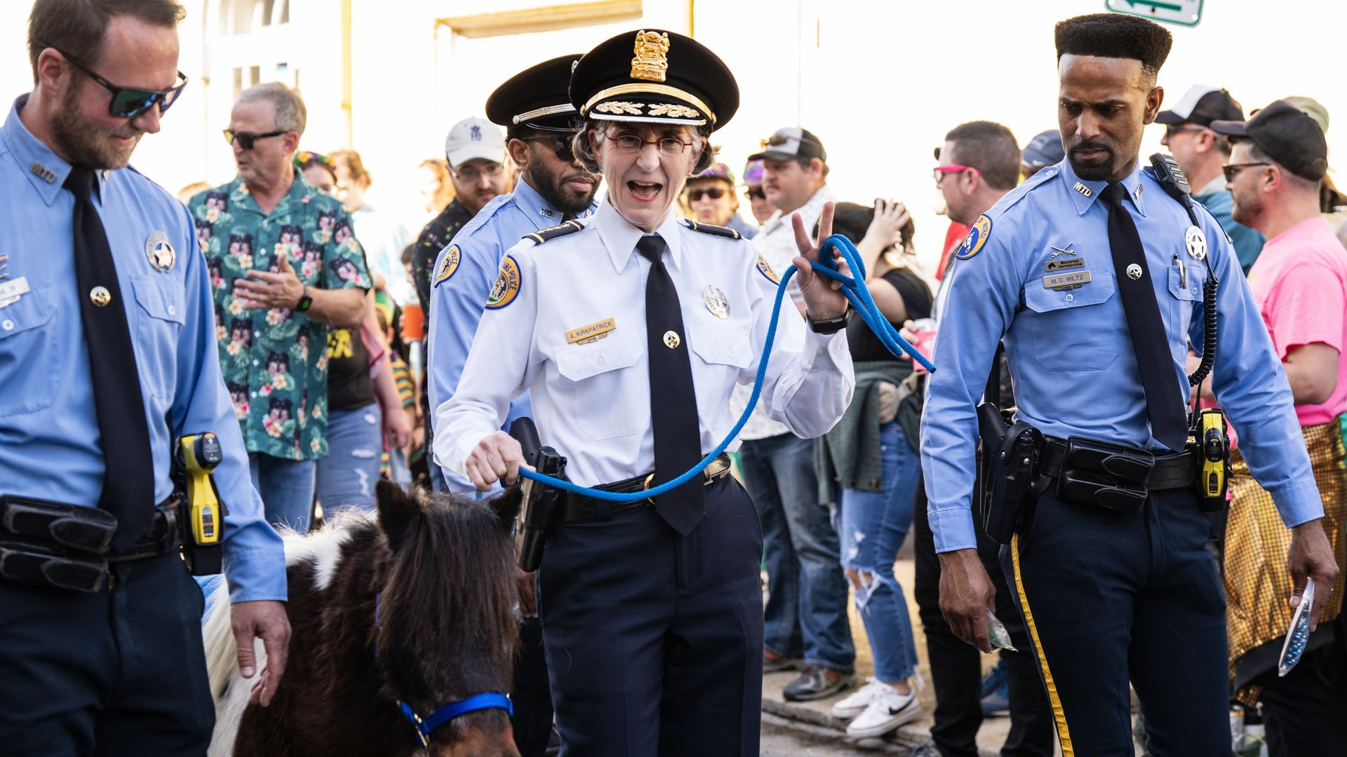 Image show Anne Kirkpatrick waving and walking with a horse.