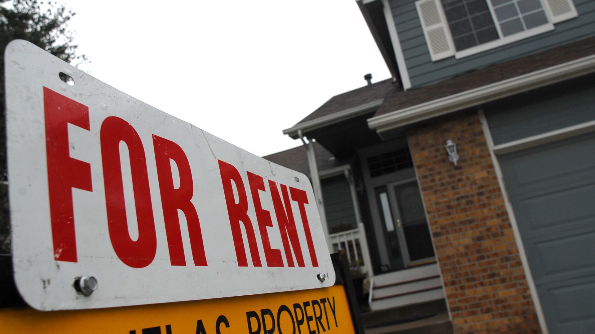 A sign in front of a home for rent