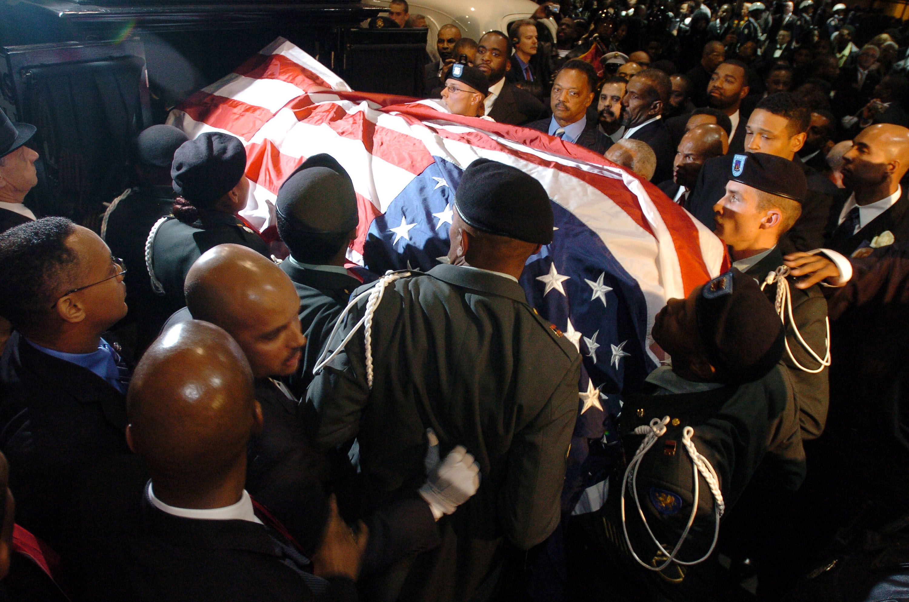 The Rev. Jesse Jackson (top center), alongside former Mayor Kwame Kilpatrick as a military honor guard carries Rosa Parks' casket in Detroit in 2005.