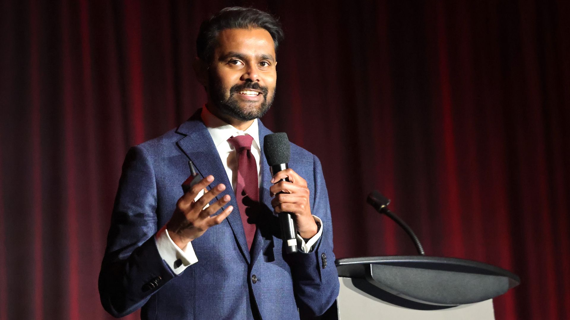 Mervin Jebaraj presents on stage. 
