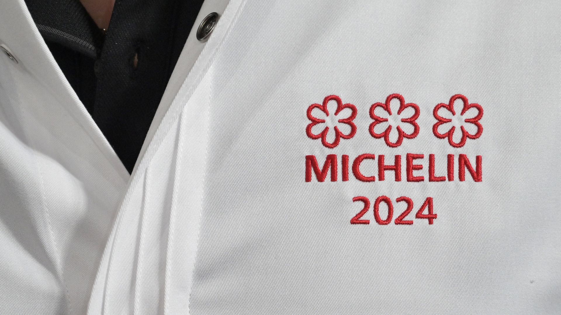 A chef's coat is embroidered with the red Michelin logo for 2024. 