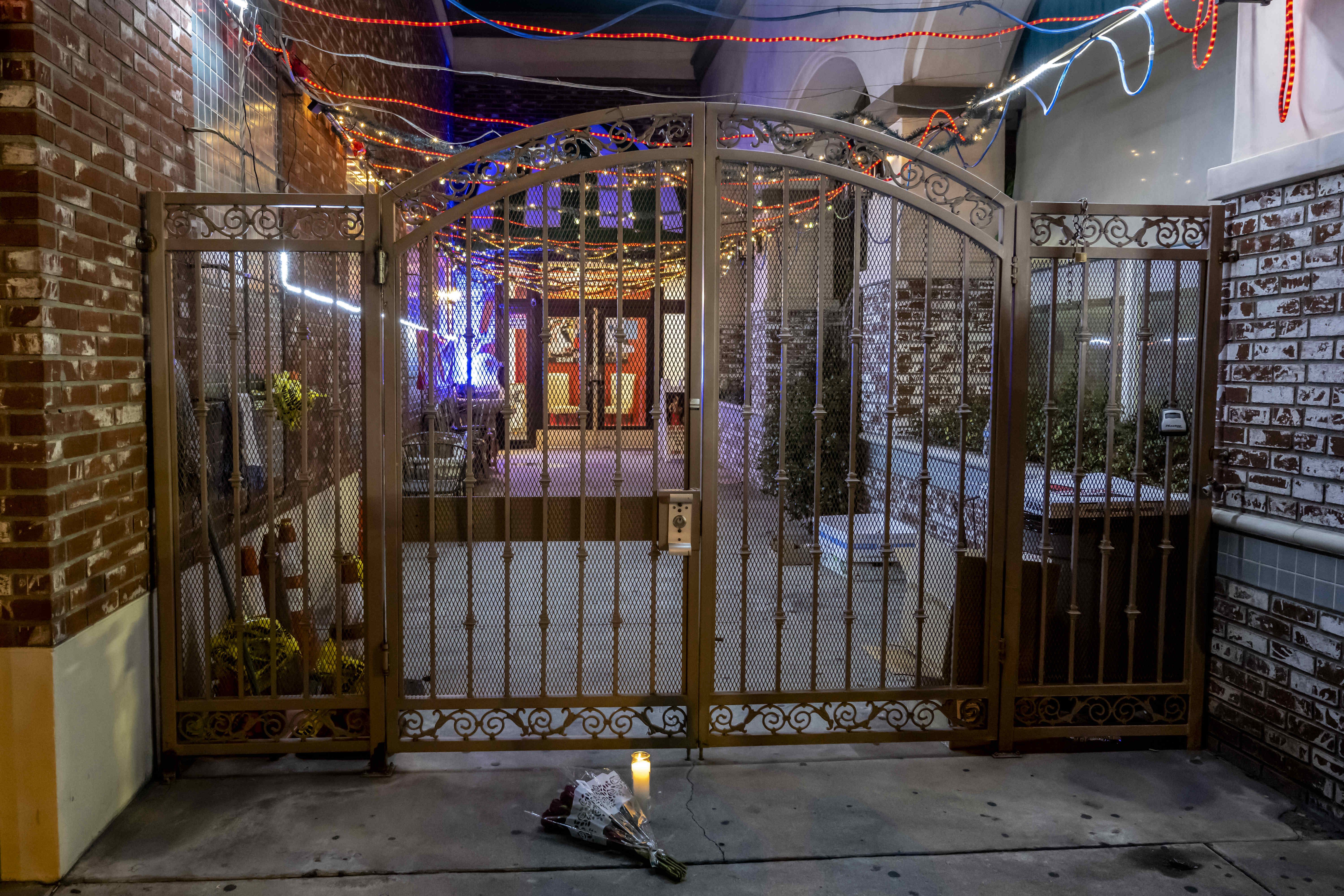  Flowers and a candle placed at the entrance to the Star Ballroom Dance Studio after police took down the crime scene tape in Monterey Park on Sunday. 