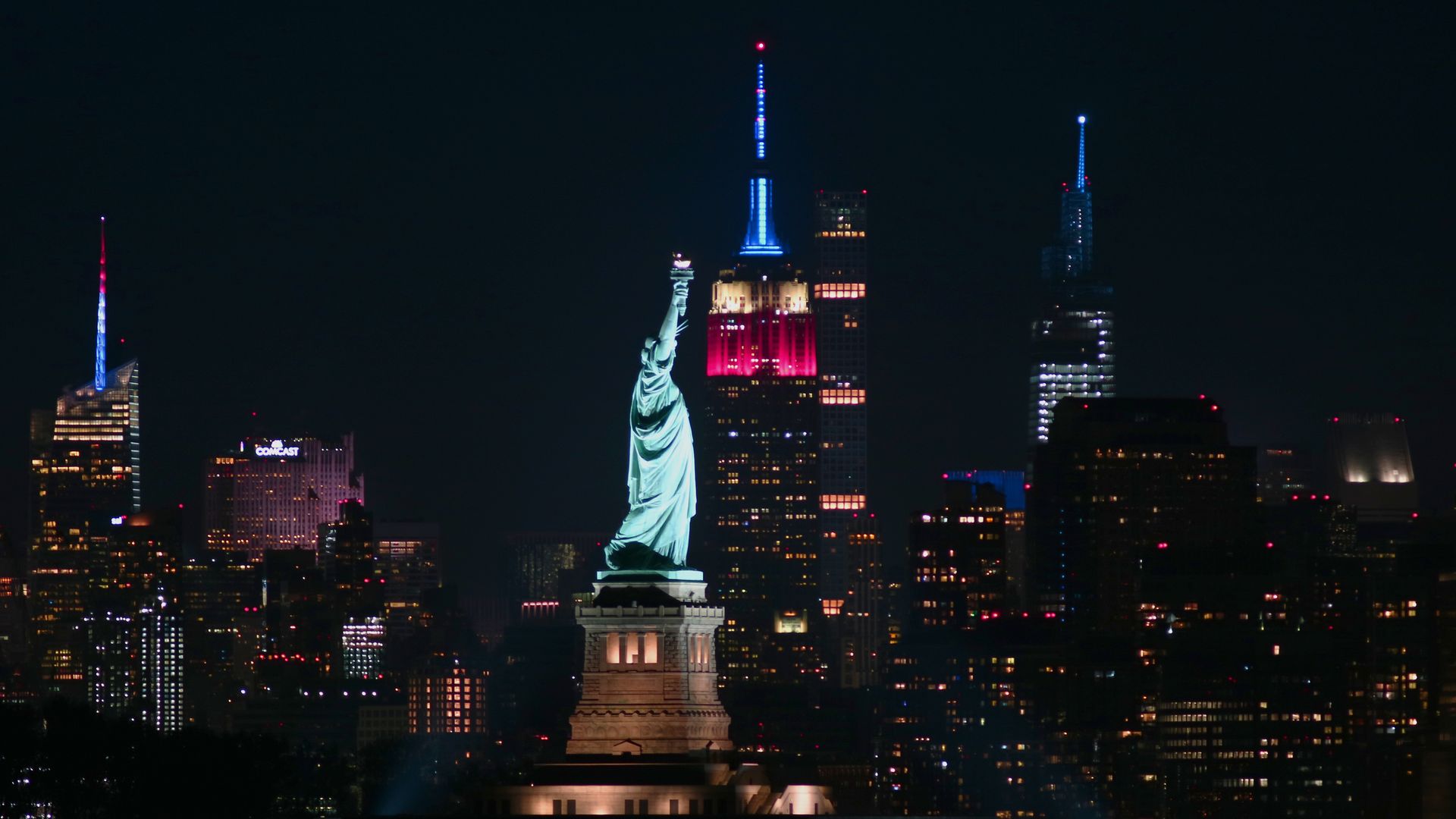 The Empire State Building lit in red white and blue beside the Statue of Liberty to mark the victory of Joe Biden in the 2020 Presidential election on November 7