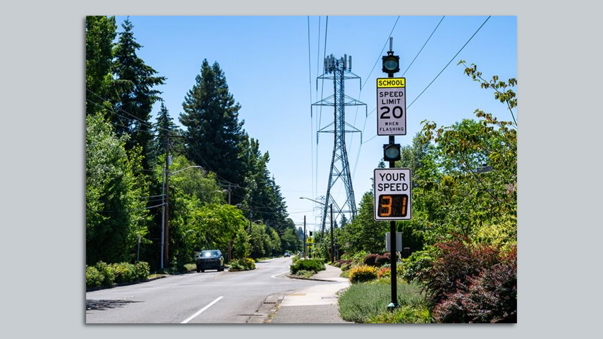 a road with a 20 MPH  speed limit sign and a digital tracker that says someone is driving at 31mph