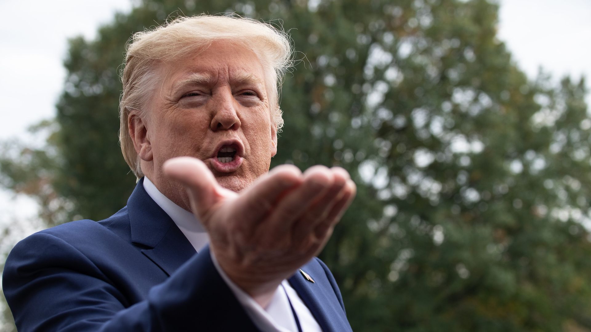 In this image, Trump speaks to the camera while gesturing.