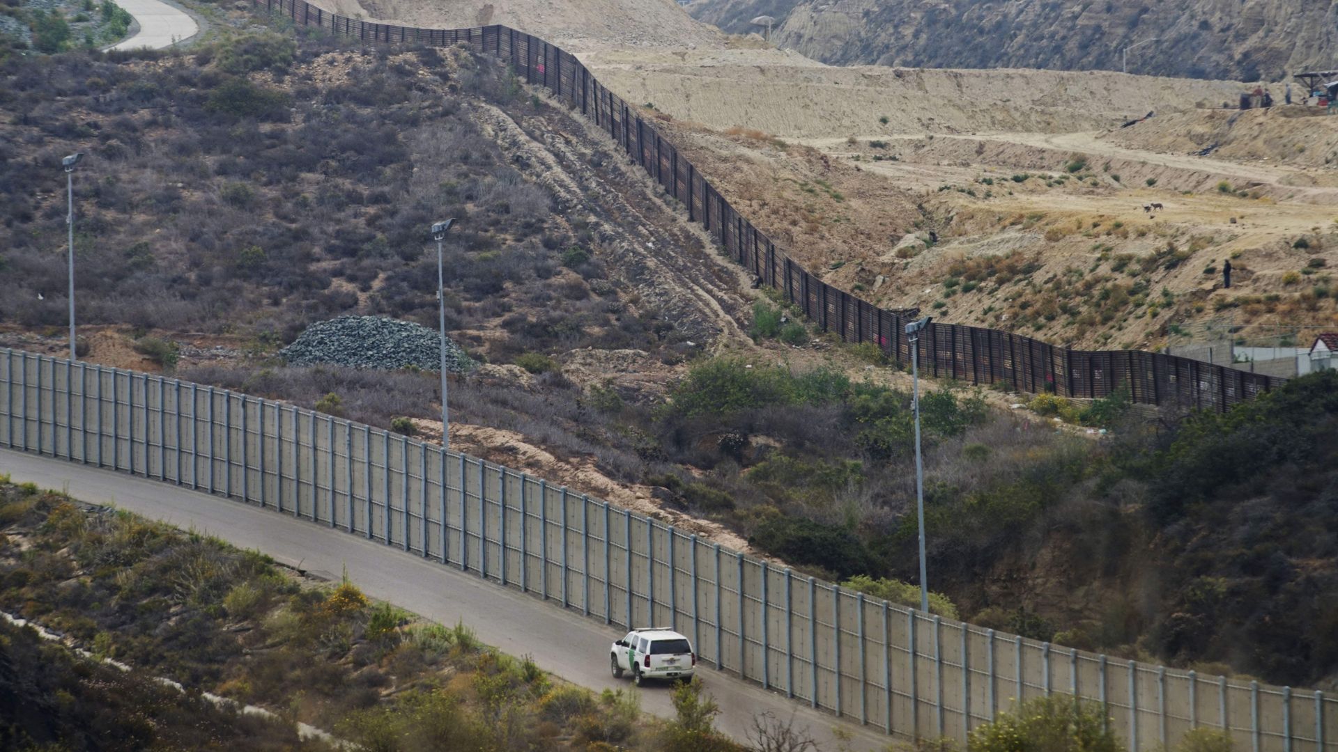 A section of the border wall on the souther border with rolling, brown hills in the background
