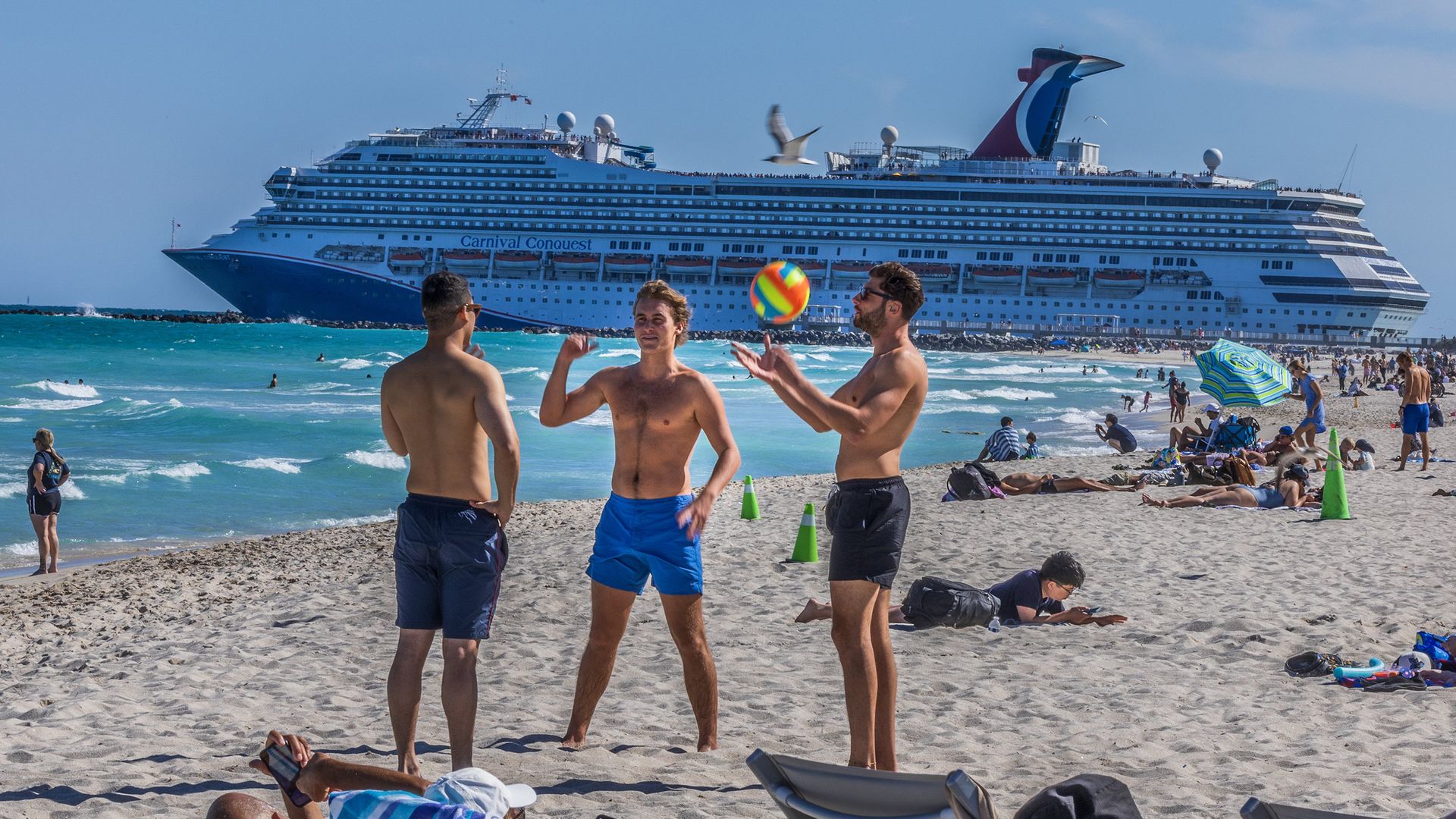The Carnival Conquest cruise ship departs from PortMiami through the Government Cut channel as beachgoers enjoy the nice weather in South Beach, during the spring break, in Miami Beach, Florida, on March 21, 2025. (Pedro Portal/Miami Herald/Tribune News Service via Getty Images)
