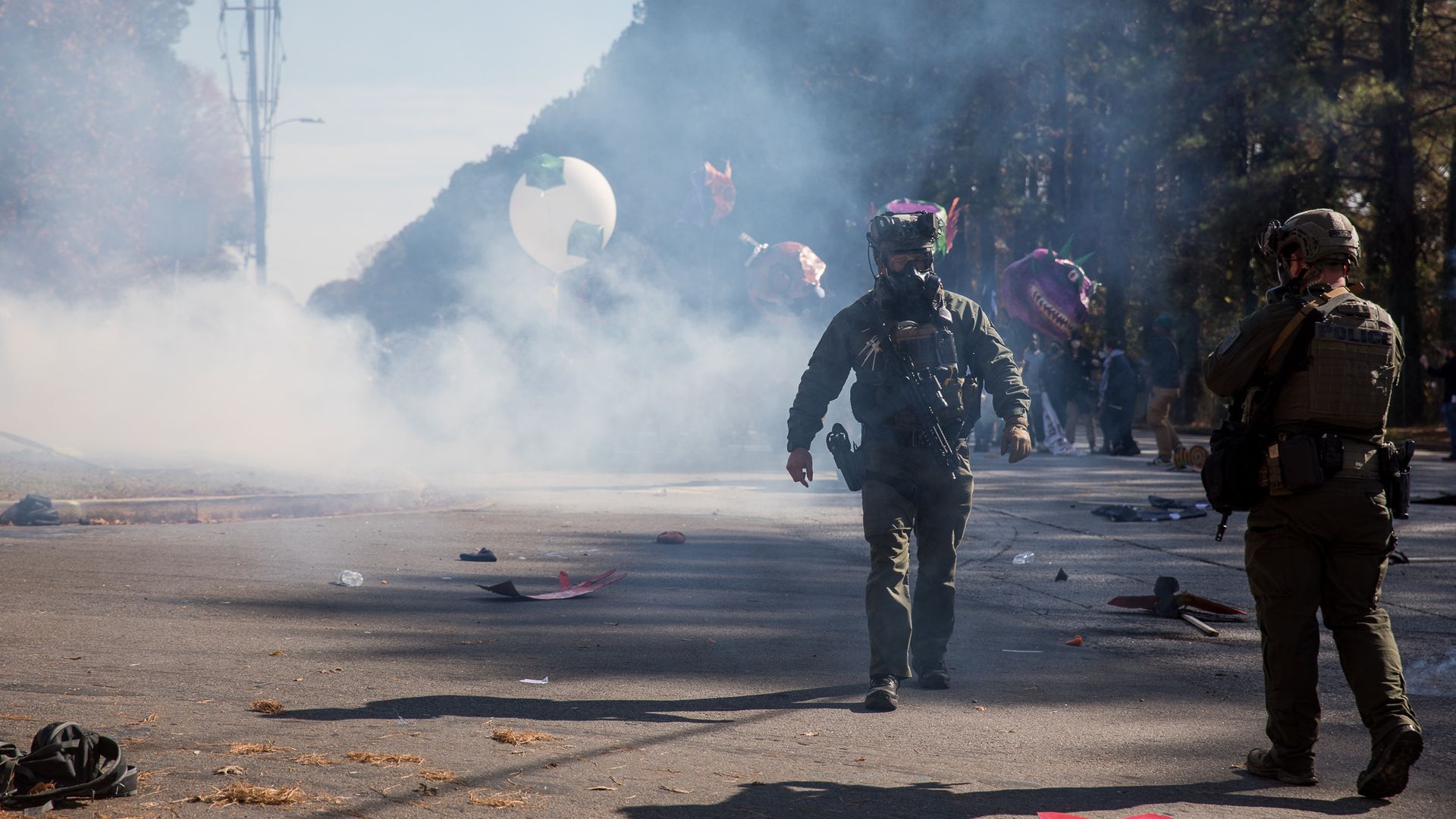 Law enforcement officers walk amid tear gas that was dispersed to break up a protest of Atlanta's public safety training center
