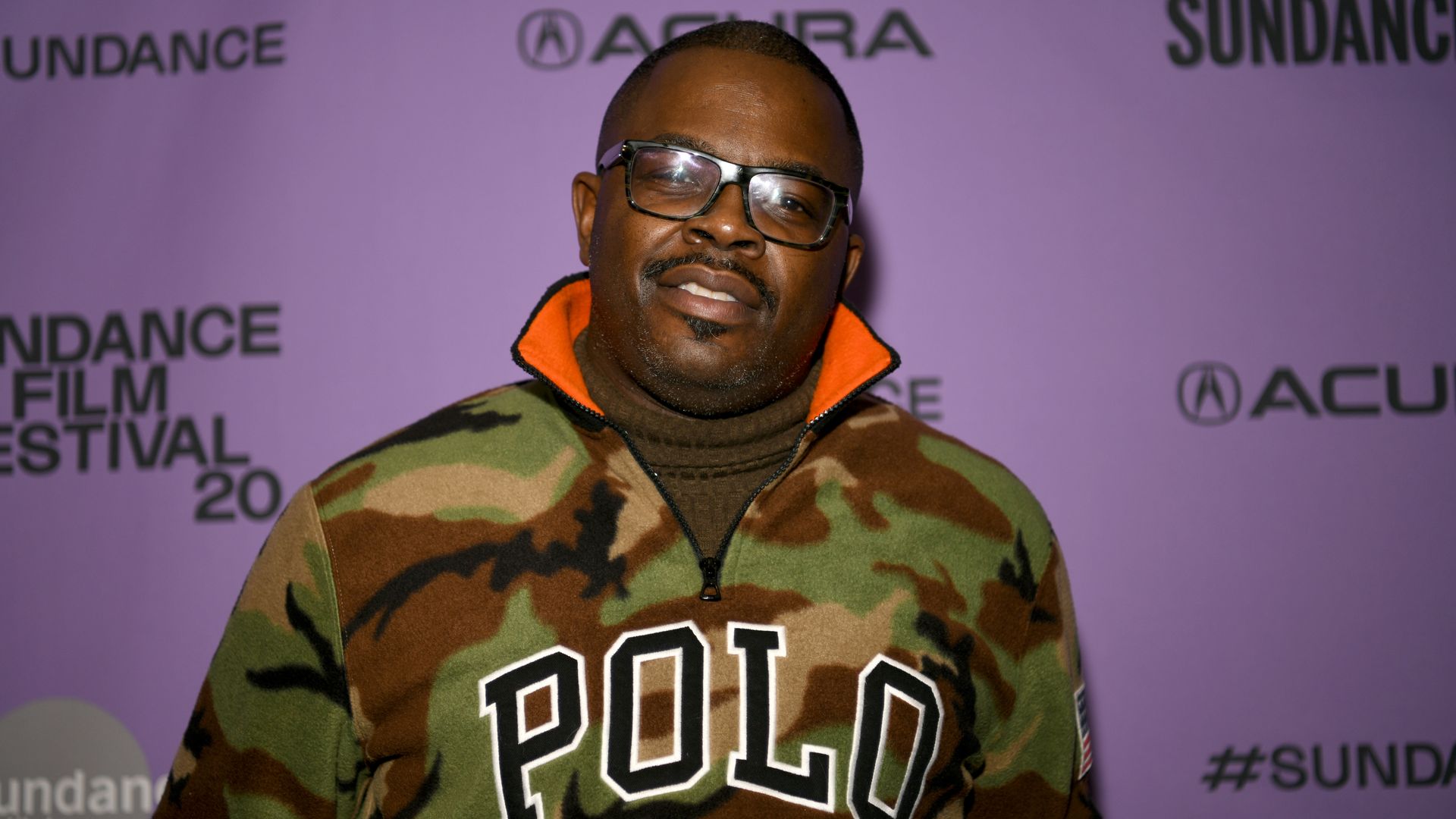 Photo of a man dressed in a POLO sweatshirt posing for cameras on red carpet. 