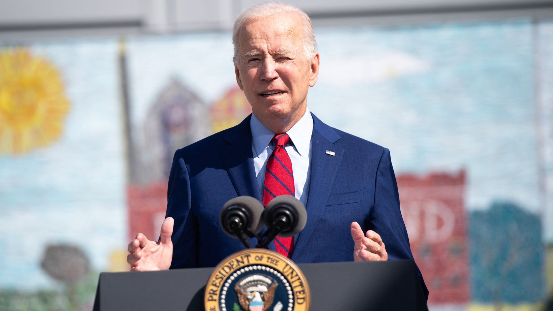President Joe Biden speaks at a podium outdoors.