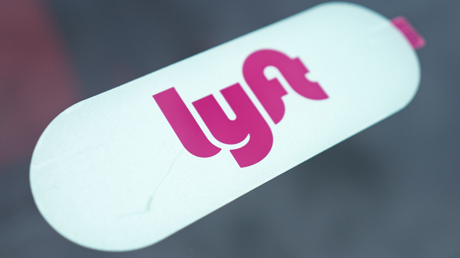 Photo of Lyft sticker in window of a car. 