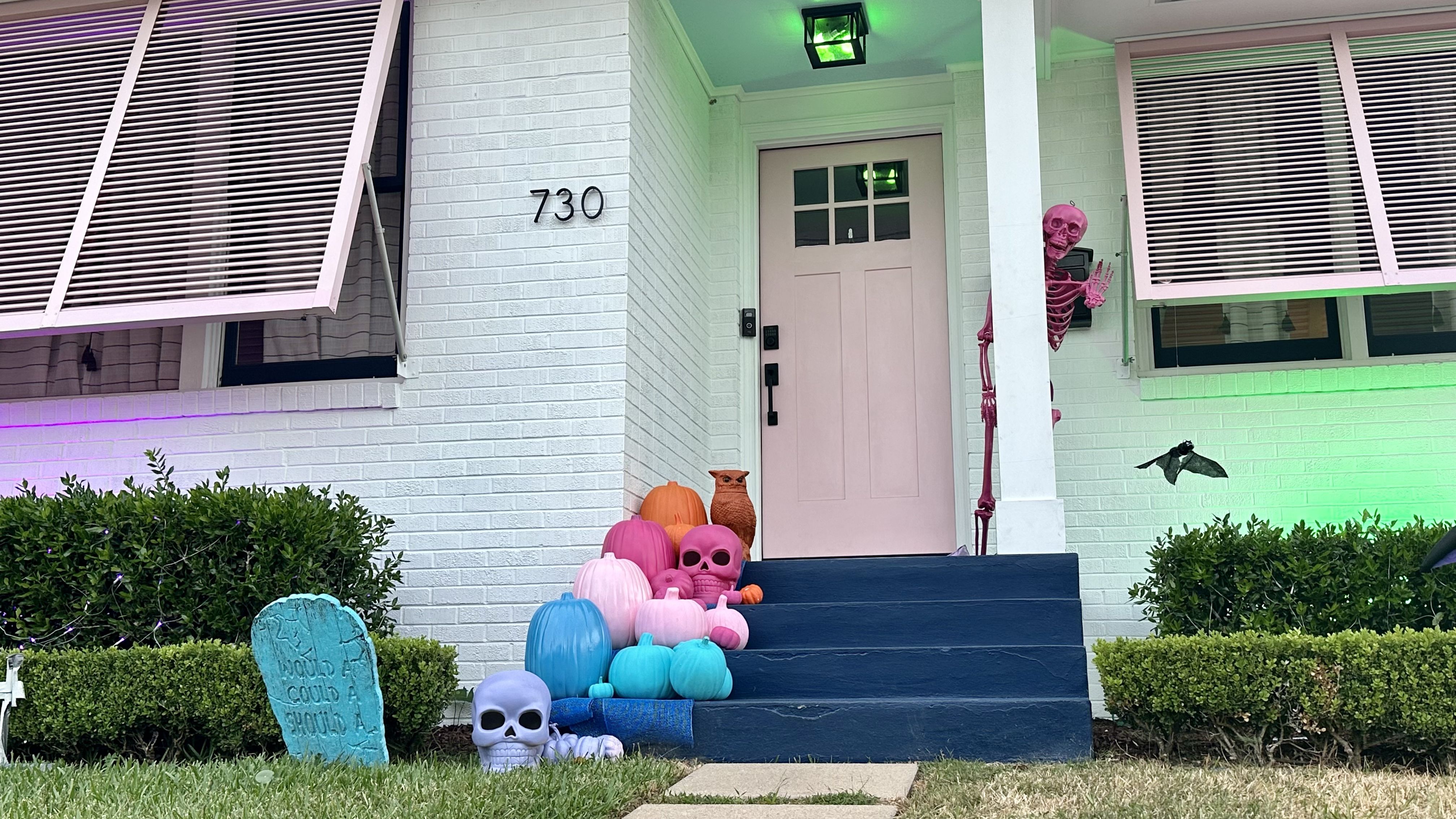 Photo shows a pink skeleton on a porch.