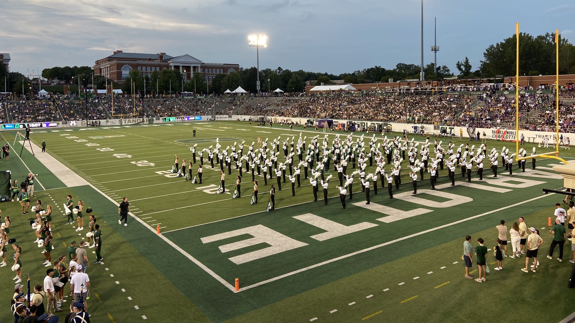 Charlotte 49ers band on the field before a football game. 