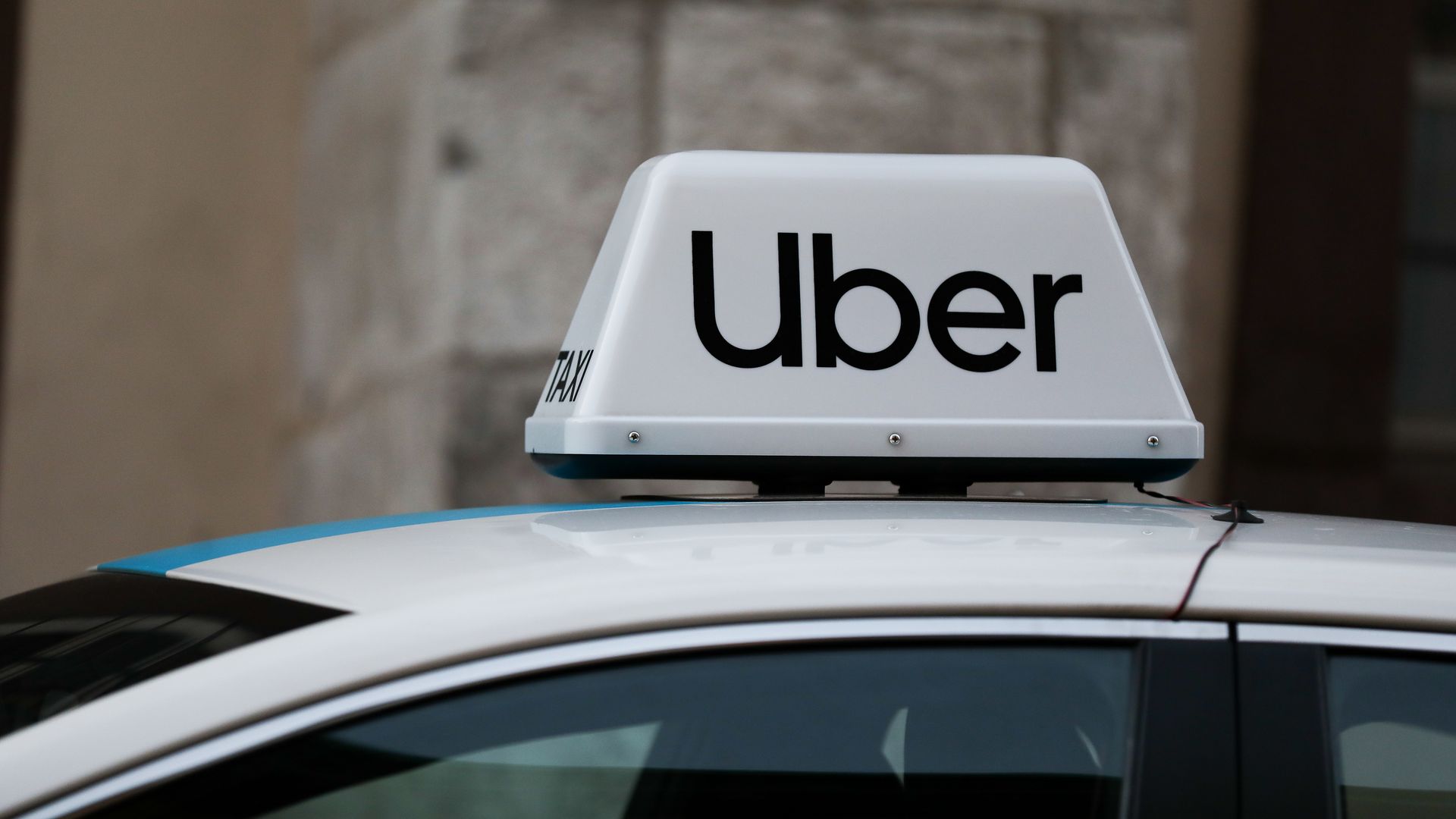 The word "Uber" on top of a taxi cab