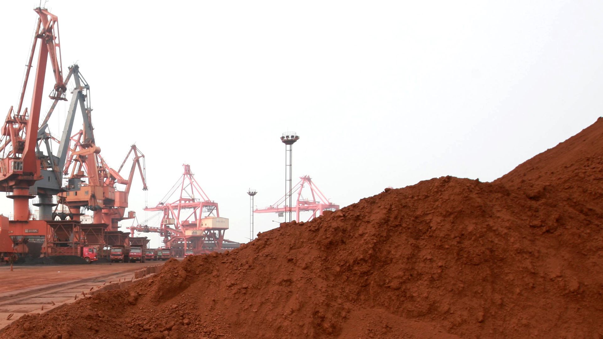 construction equipment behind a mound of soil