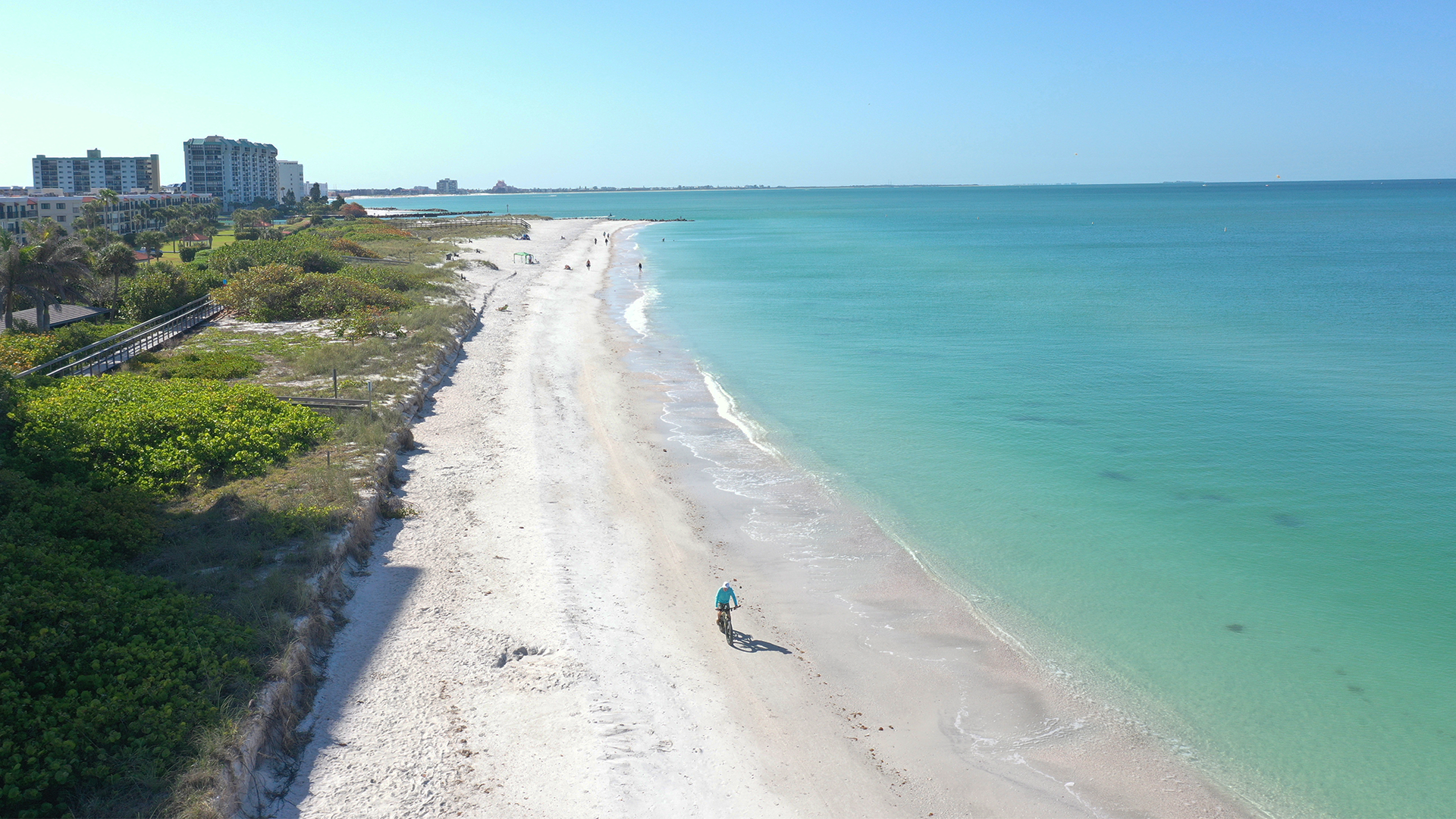aerial shot of person riding down the beach