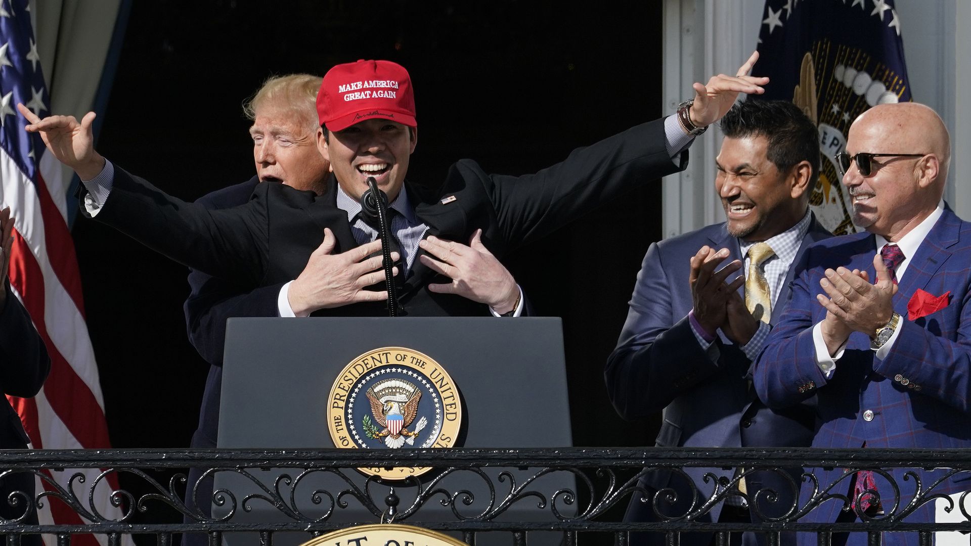 Trump holds Washington Nationals player Suzuki at the White House as two Nats players laugh next to them.