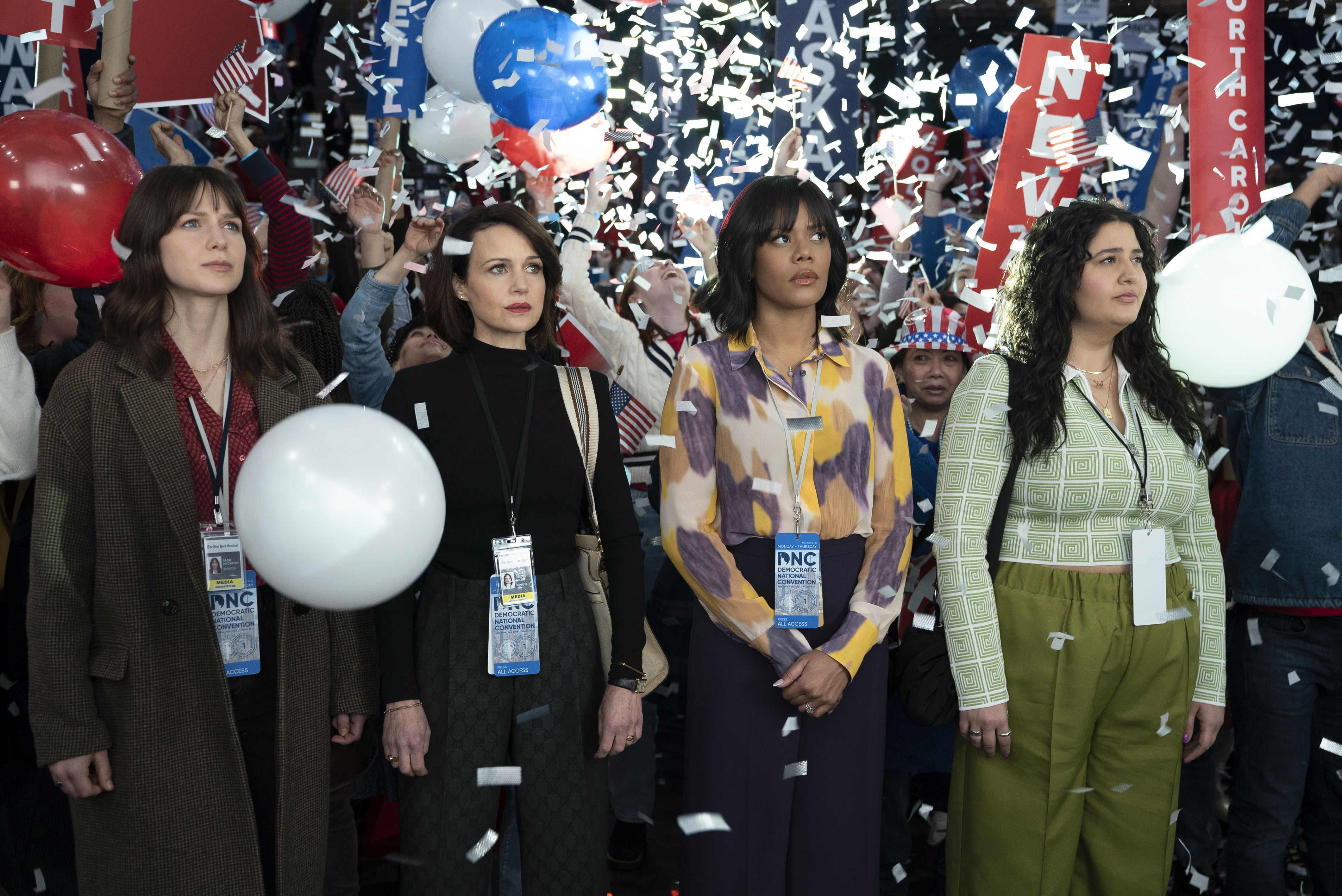 Four journalists stand at a convention on "The Girls on the Bus"