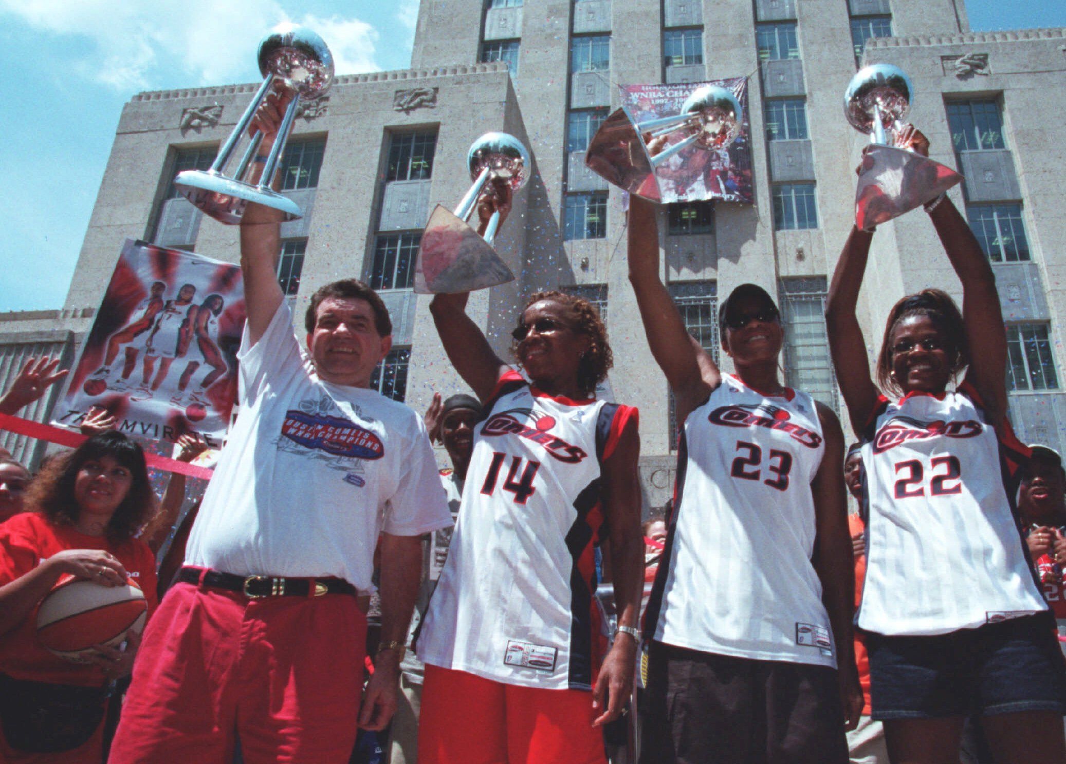 Houston Comets players hold up trophies at parade