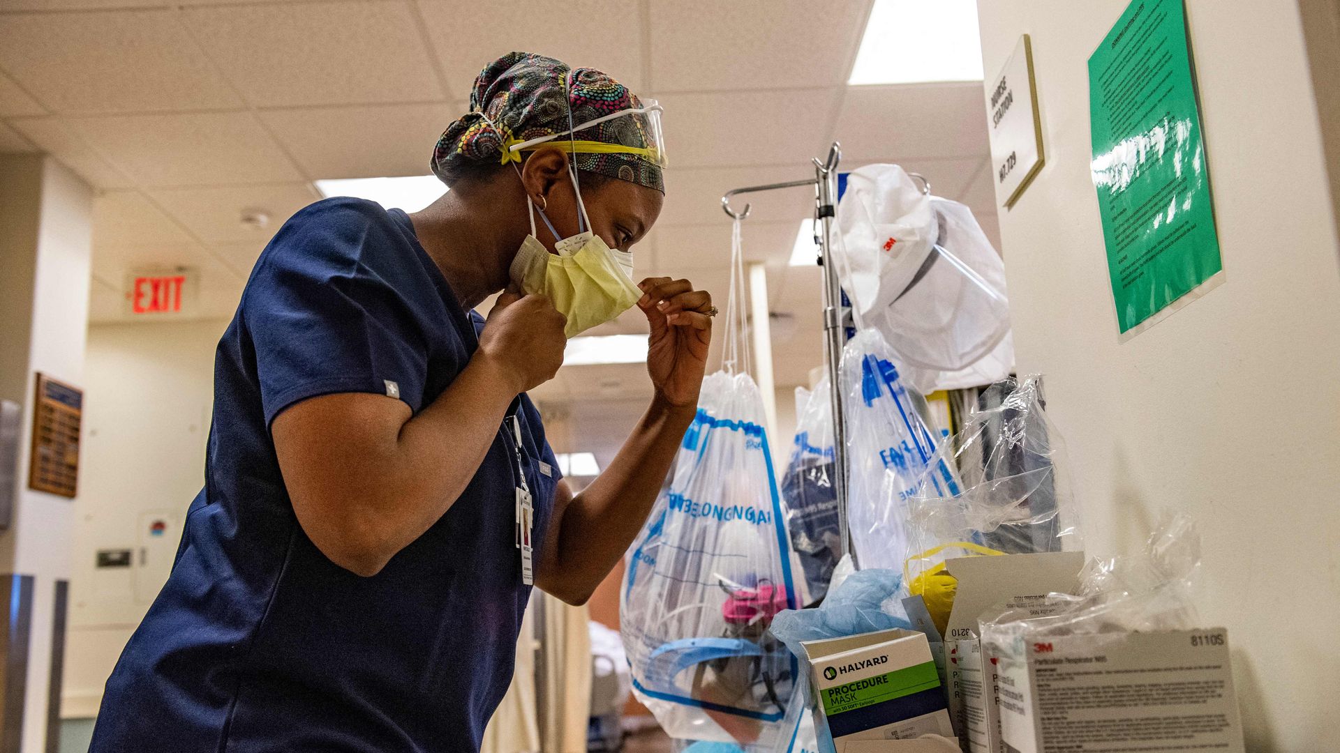 A medical workers puts on a maskbefore entering a negative pressure room with a Covid-19 patient in the ICU ward at UMass Memorial Medical Center in Worcester, Massachusetts on January 4, 2022