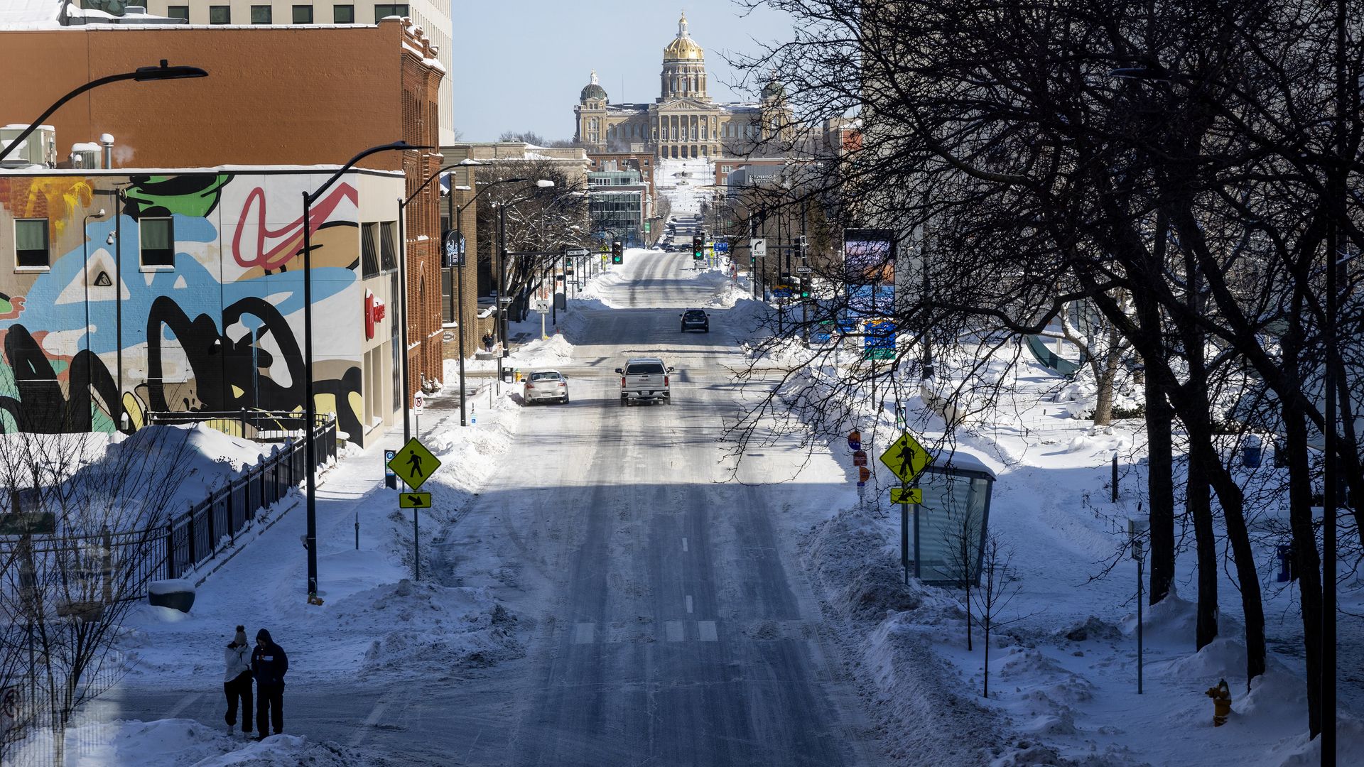  Two pedestrians brave the sub-zero temperatures downtown as extreme temperatures and snow have gripped Iowa during Iowa Caucus week on January 14, 2024 in Des Moines, Iowa.