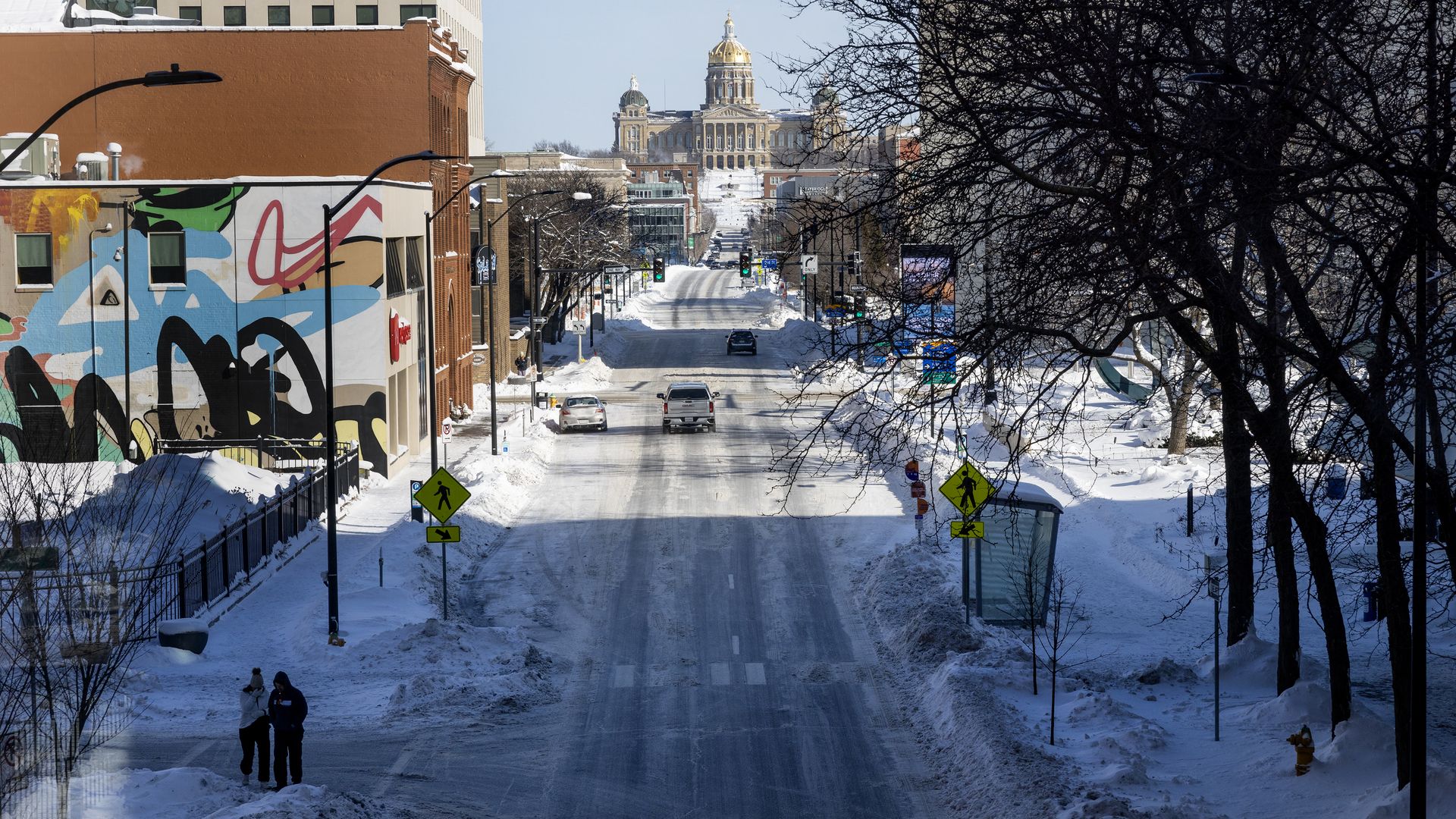 Two pedestrians brave the sub-zero temperatures downtown as extreme temperatures and snow have gripped Iowa during Iowa Caucus week on January 14, 2024 in Des Moines, Iowa.