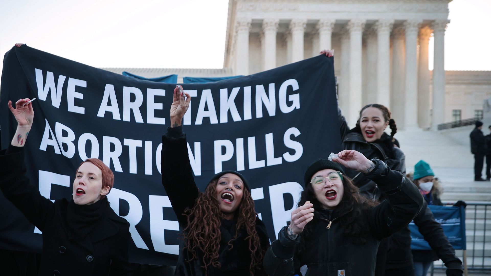 Picture of activists taking abortion pills in front of the Supreme Court building