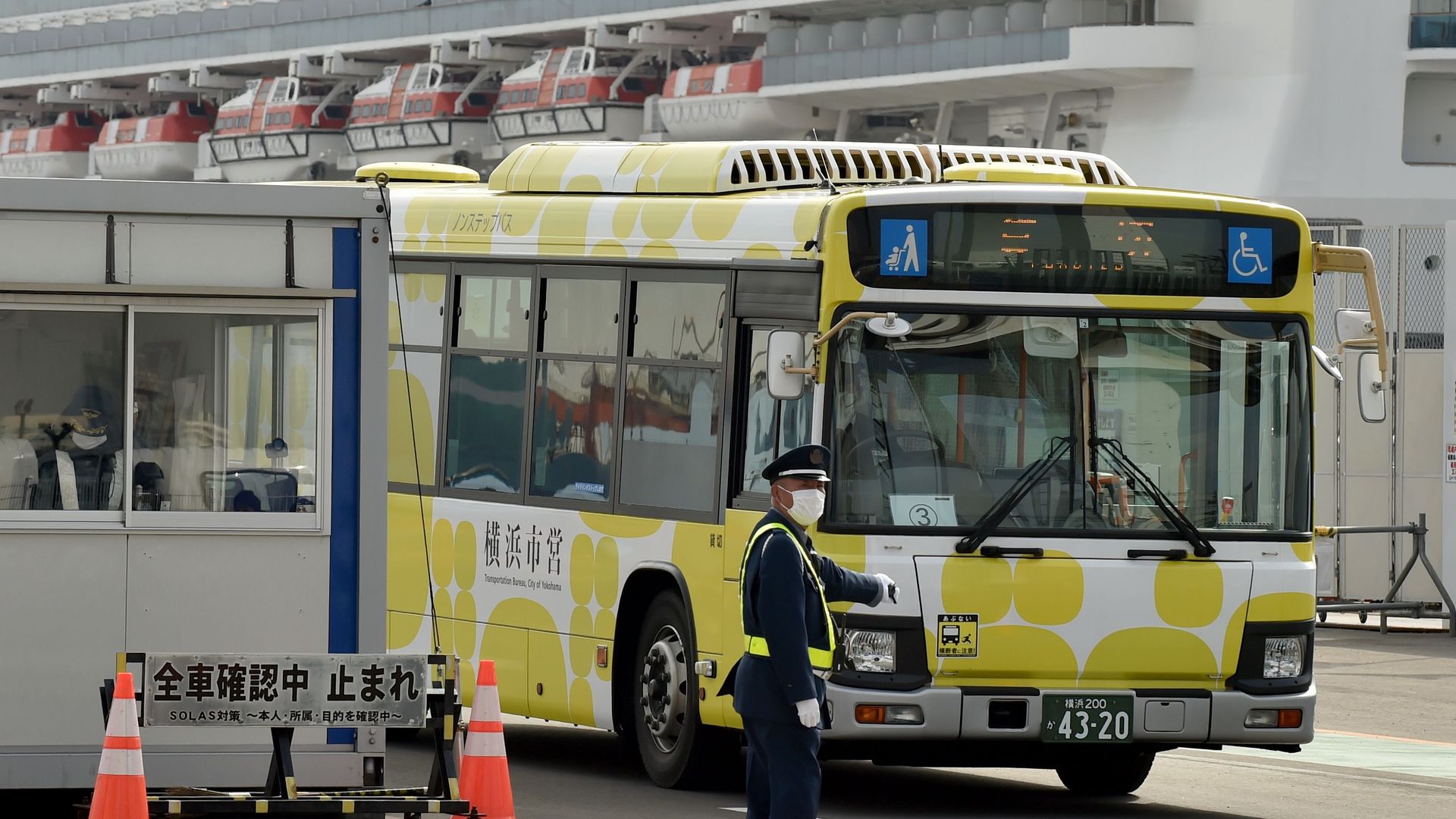 A bus carrying passengers who disembarked from the Diamond Princess cruise ship leaves the Daikoku Pier Cruise Terminal in Yokohama on February 20