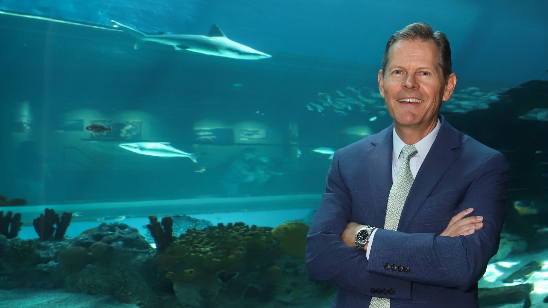 Tom Schmid, the new CEO of the Columbus Zoo and Aquarium, stands in front of an aquarium 