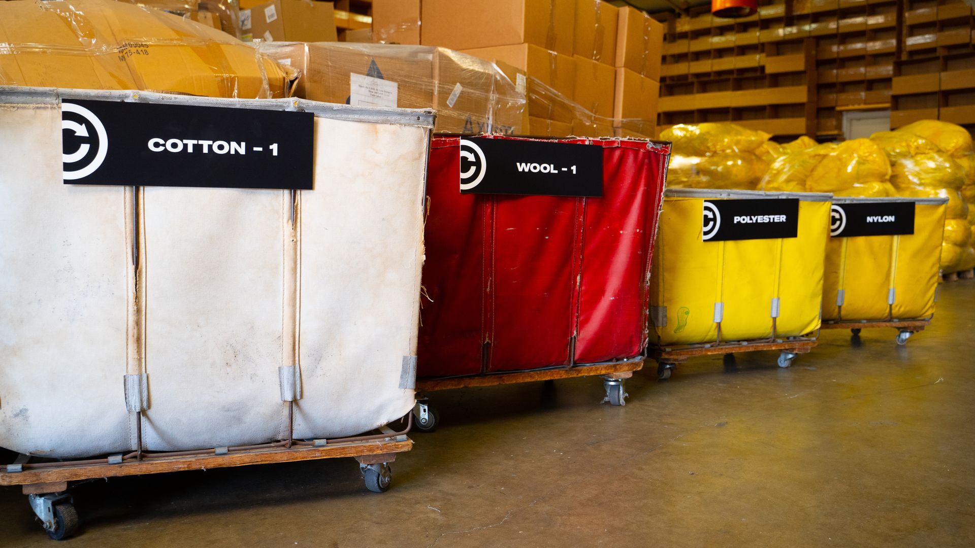 Colored bins, which sit in a warehouse, are used to sort textiles that will be recycled.