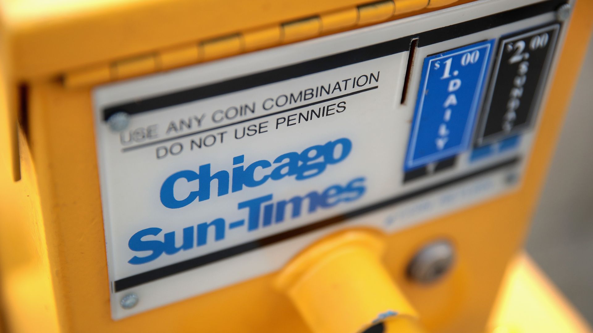 Photo of a newspaper box with the words "Chicago Sun-Times" on the front 