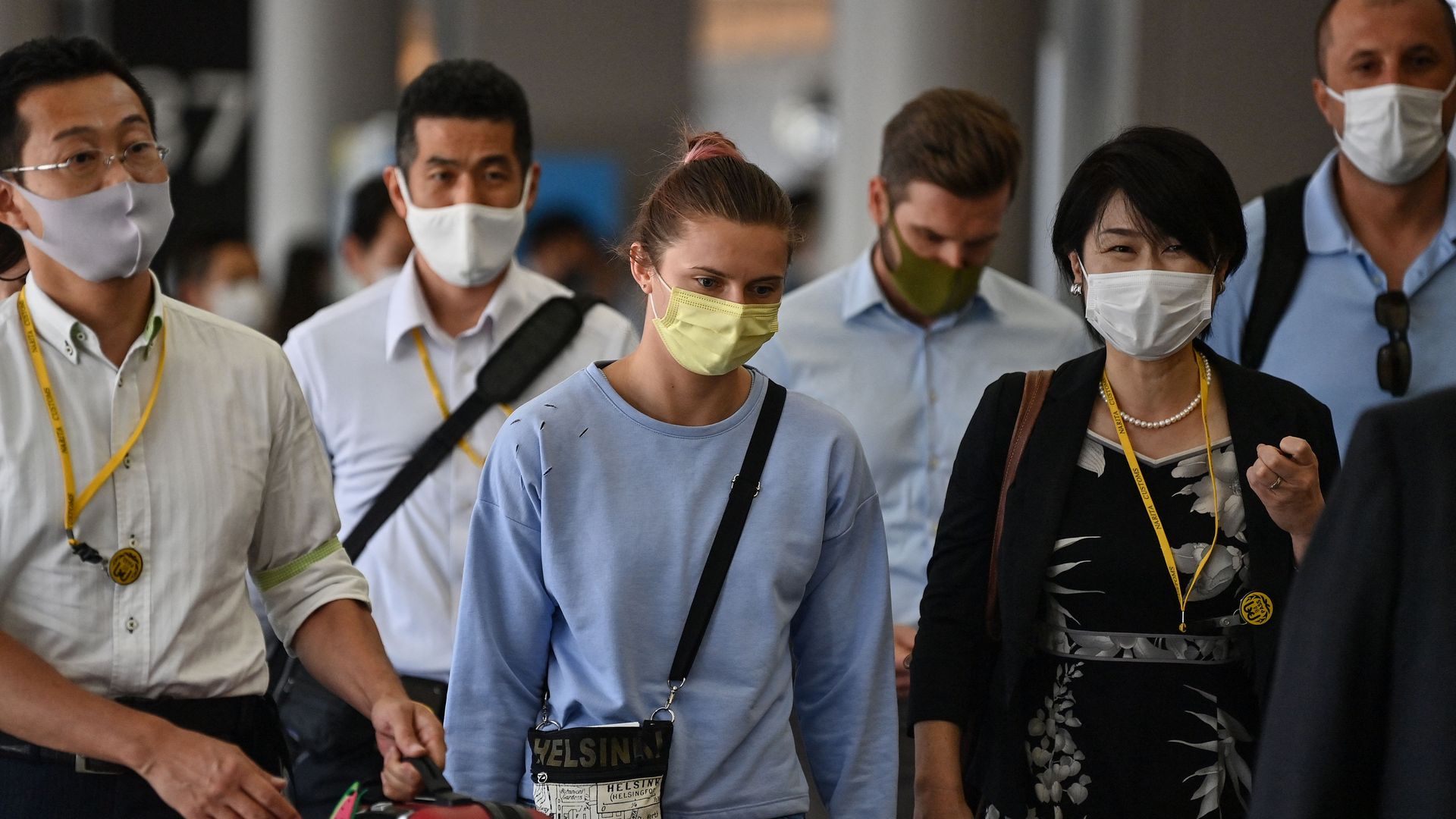 Belarus athlete Krystsina Tsimanouskaya (C) walks through Terminal 1 before boarding her Vienna-bound flight at Narita International Airport in Narita, Chiba Prefecture, outside Tokyo on August 4