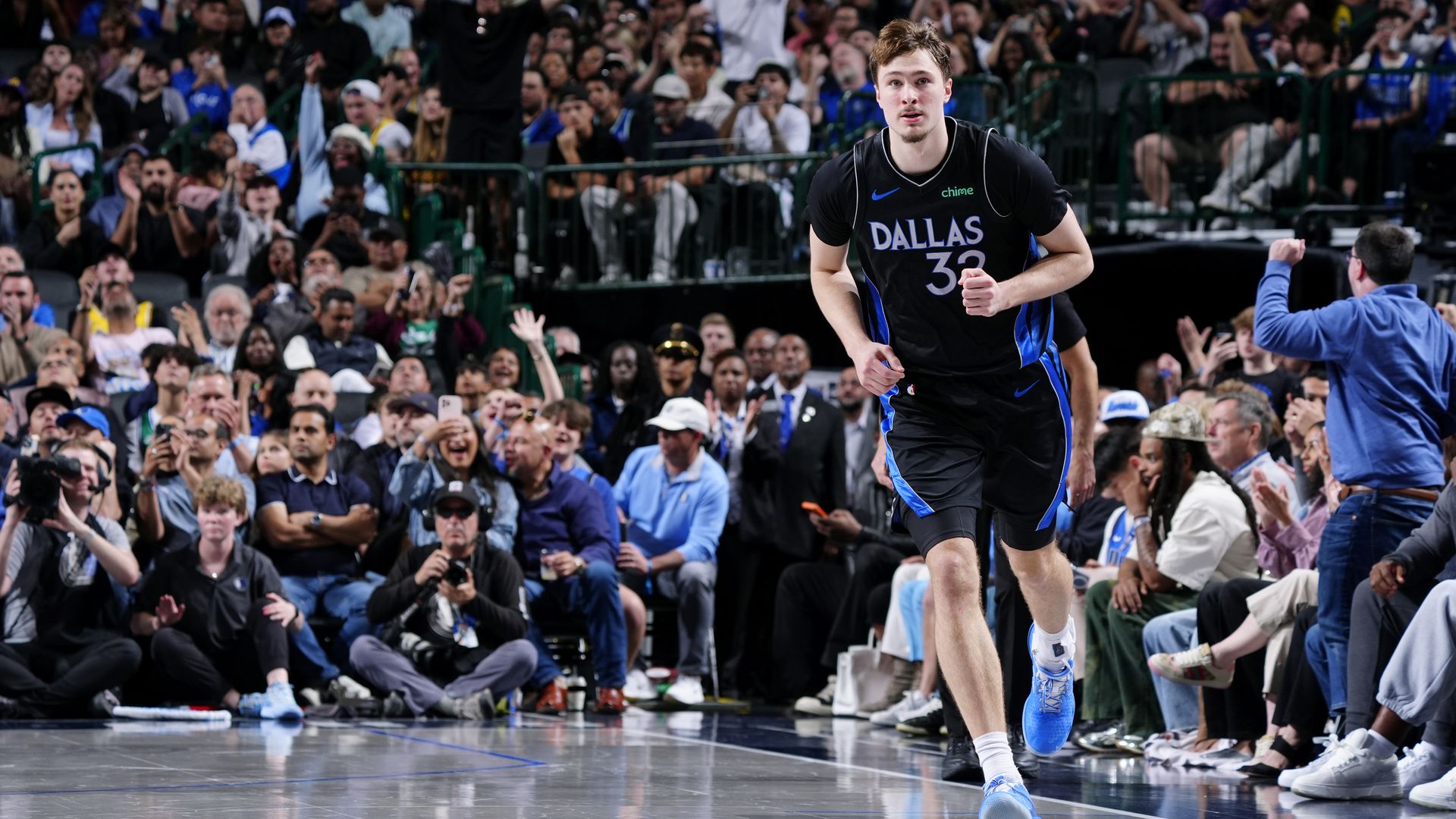 Cooper Flagg runs on the court with fans in the background