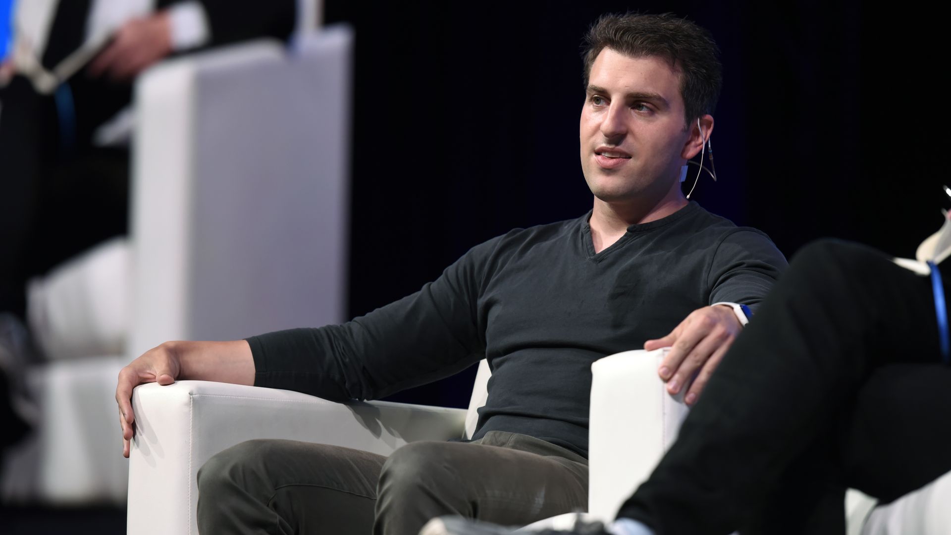 CEO of airbnb brian chesky sitting in a chair.